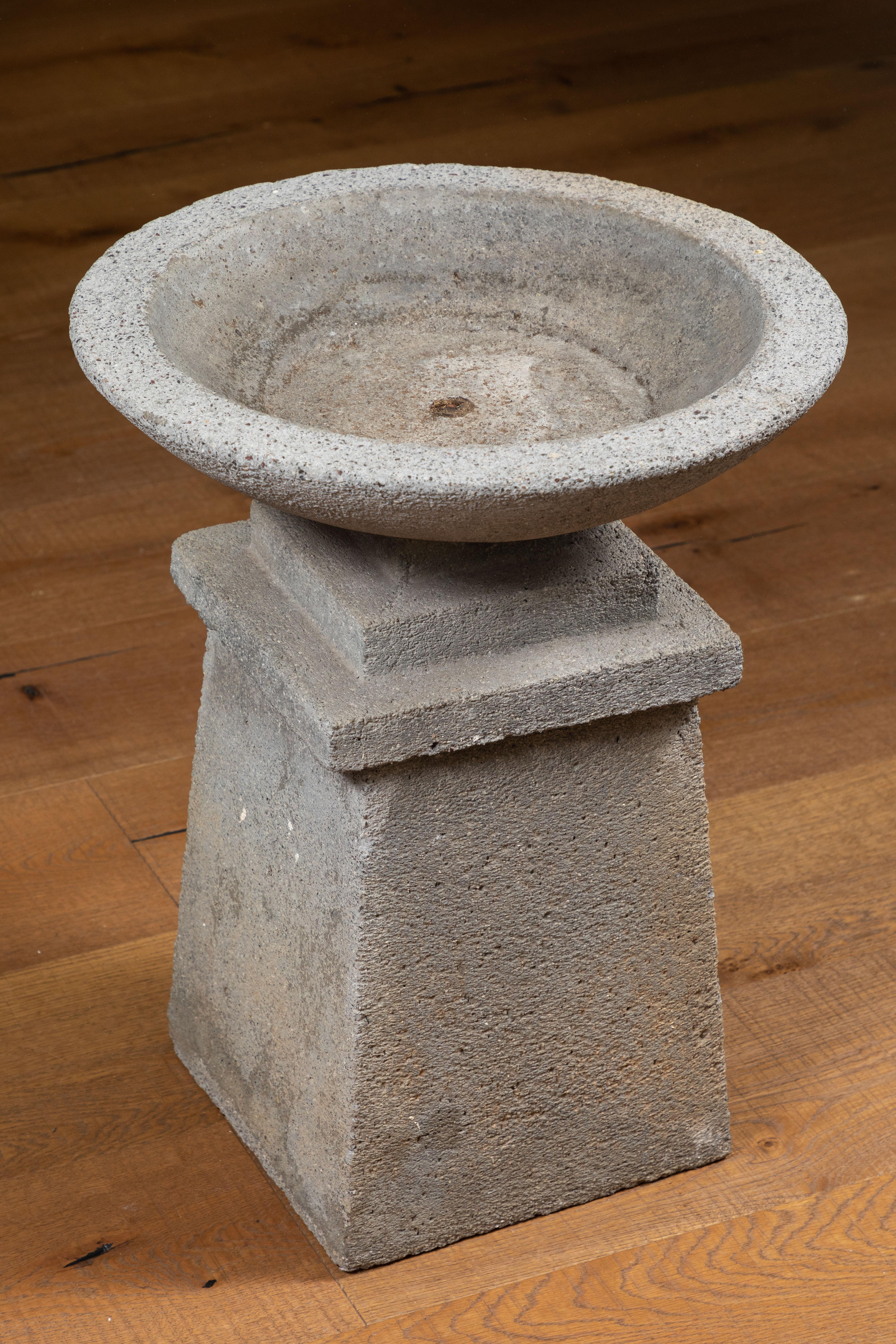 American cast concrete garden planter featuring a bowl top and pedestal base.