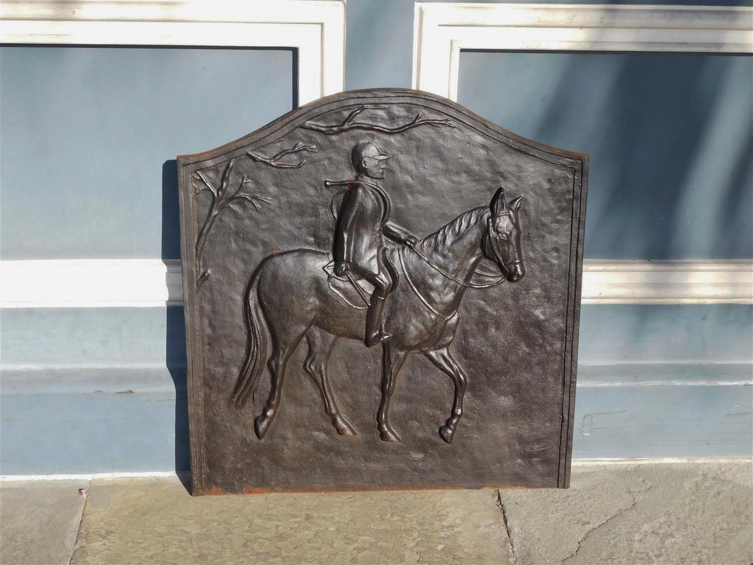 American cast iron foliage fireback with gentleman riding on horse and riding crop mounted on shoulder, 20th century, Virginia.