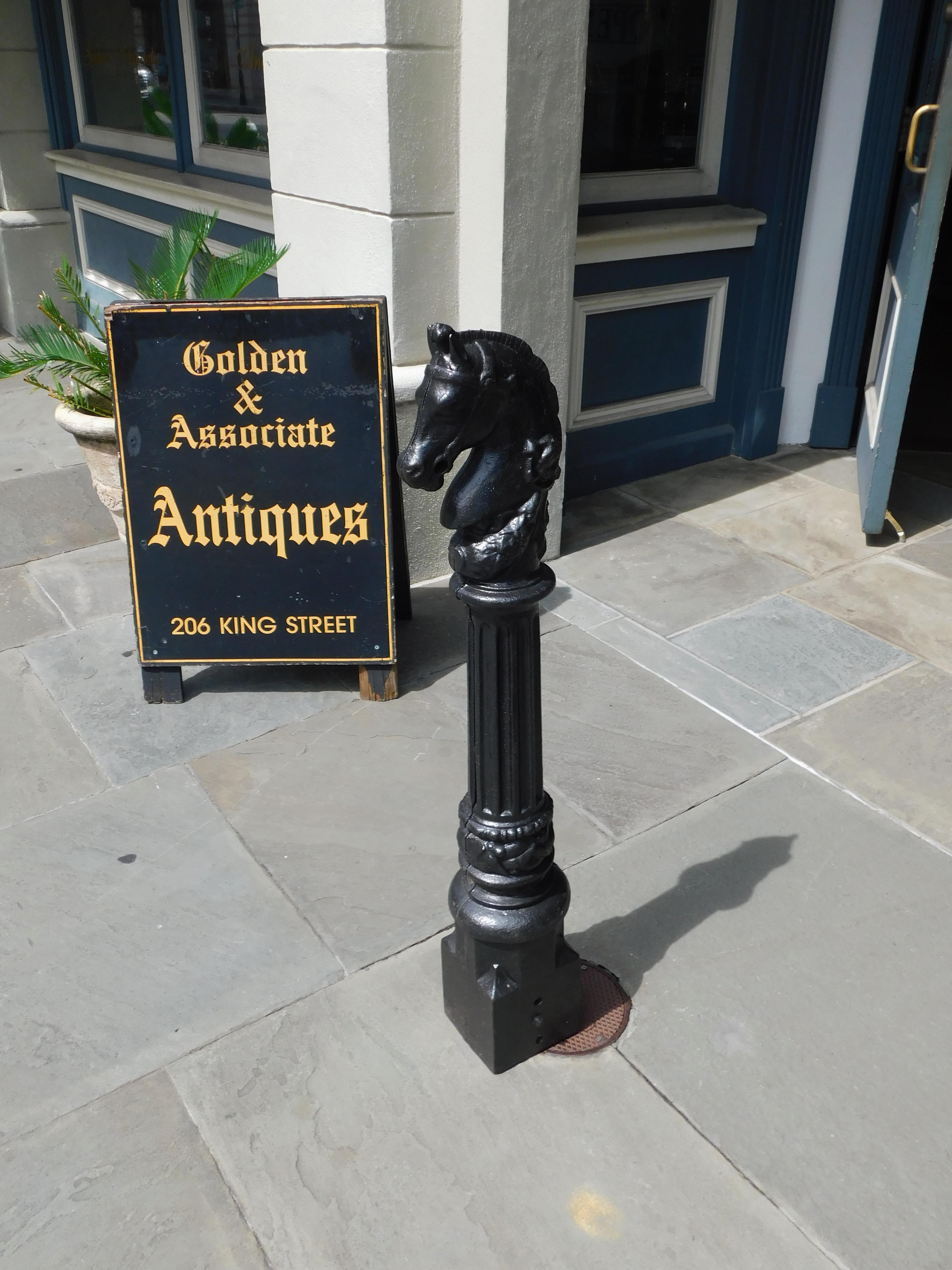 American cast iron and painted horse head hitching post with a central fluted ringed column resting on a squared base, Mid 19th Century.