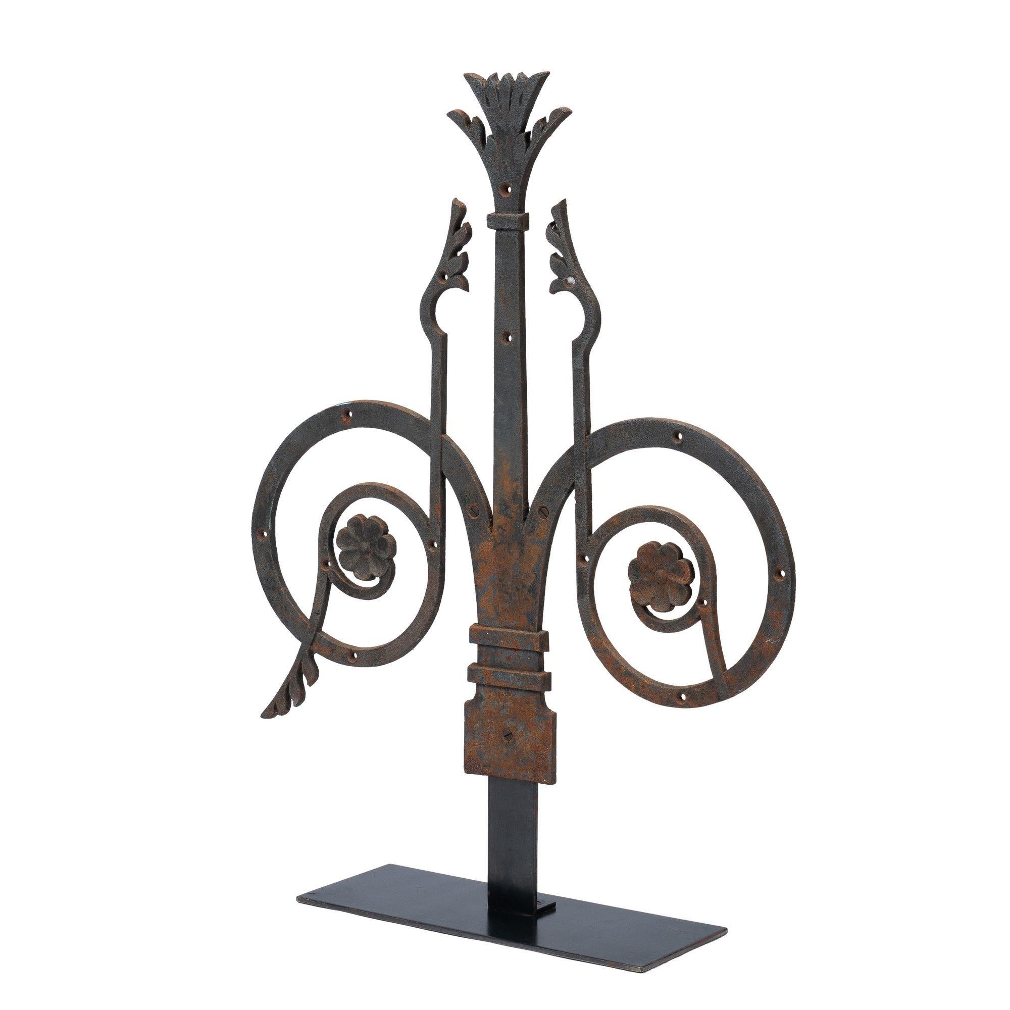 American cast iron strapwork style carriage door hinge in the Romanesque taste. Mounted on a custom iron stand.
American, circa 1885.
Condition: The hinge has a slight patina of rust and some surface marks are visible throughout. Wear commensurate