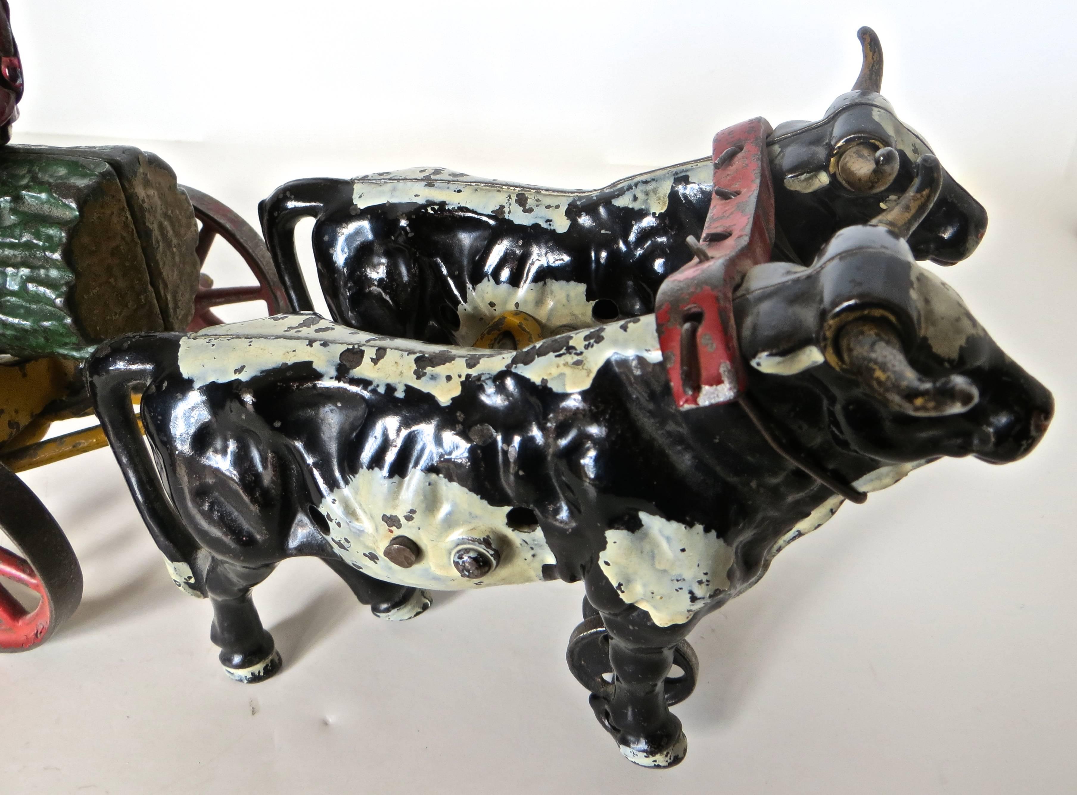 This charismatic turn of the century American cast iron floor toy (children rolled it around on the floor by hand) made by the Hubley Manufacturing Company in Lancaster, Pennsylvania, circa 1906 consists of: two oxen pulling a separate carriage with