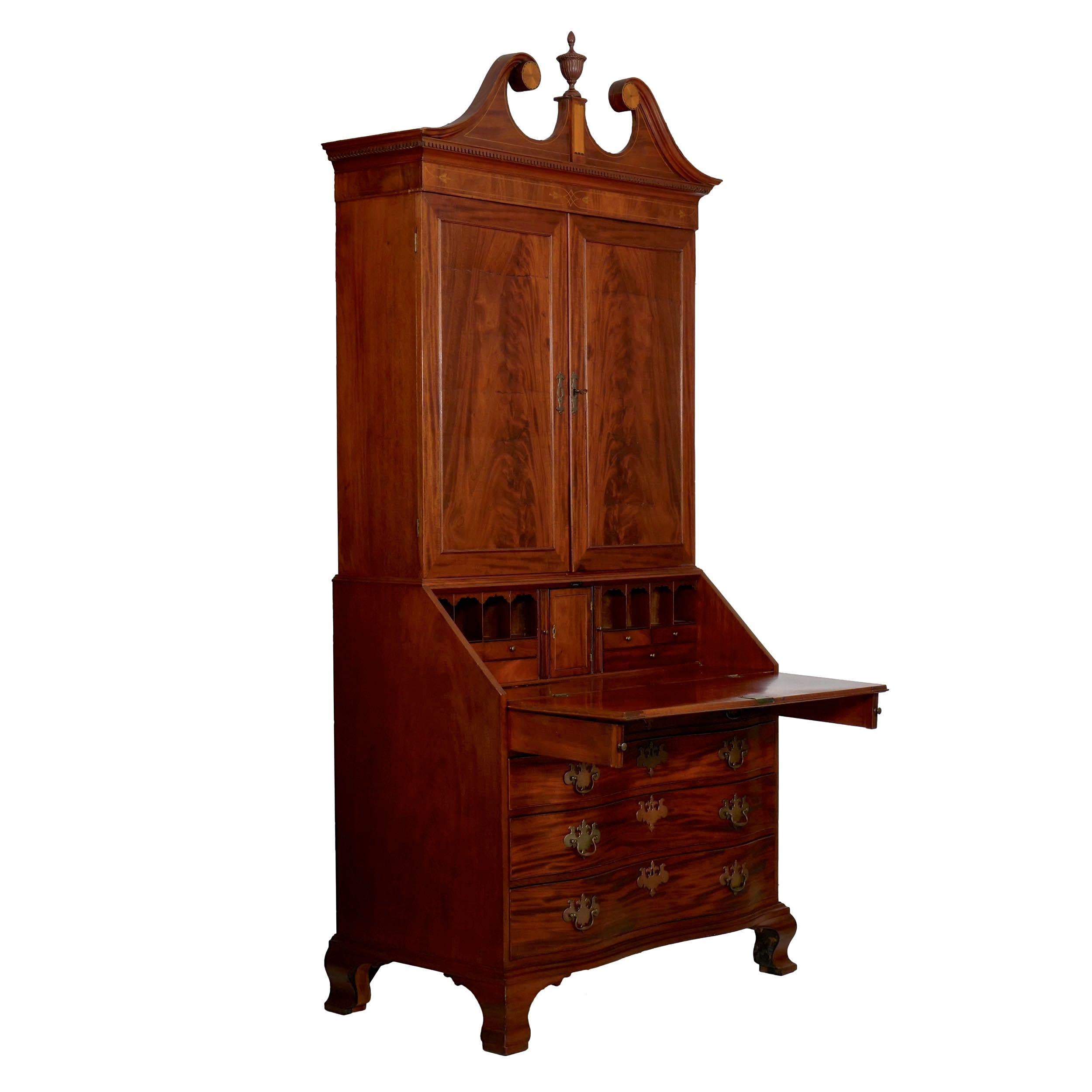 The crown is self-contained and lifts off of the bookcase, this crafted with open dovetails at the rear corners and affixing to the bookcase with screws. The swan's neck pediment is beautifully molded with an intricate patera pinwheel motif flanking