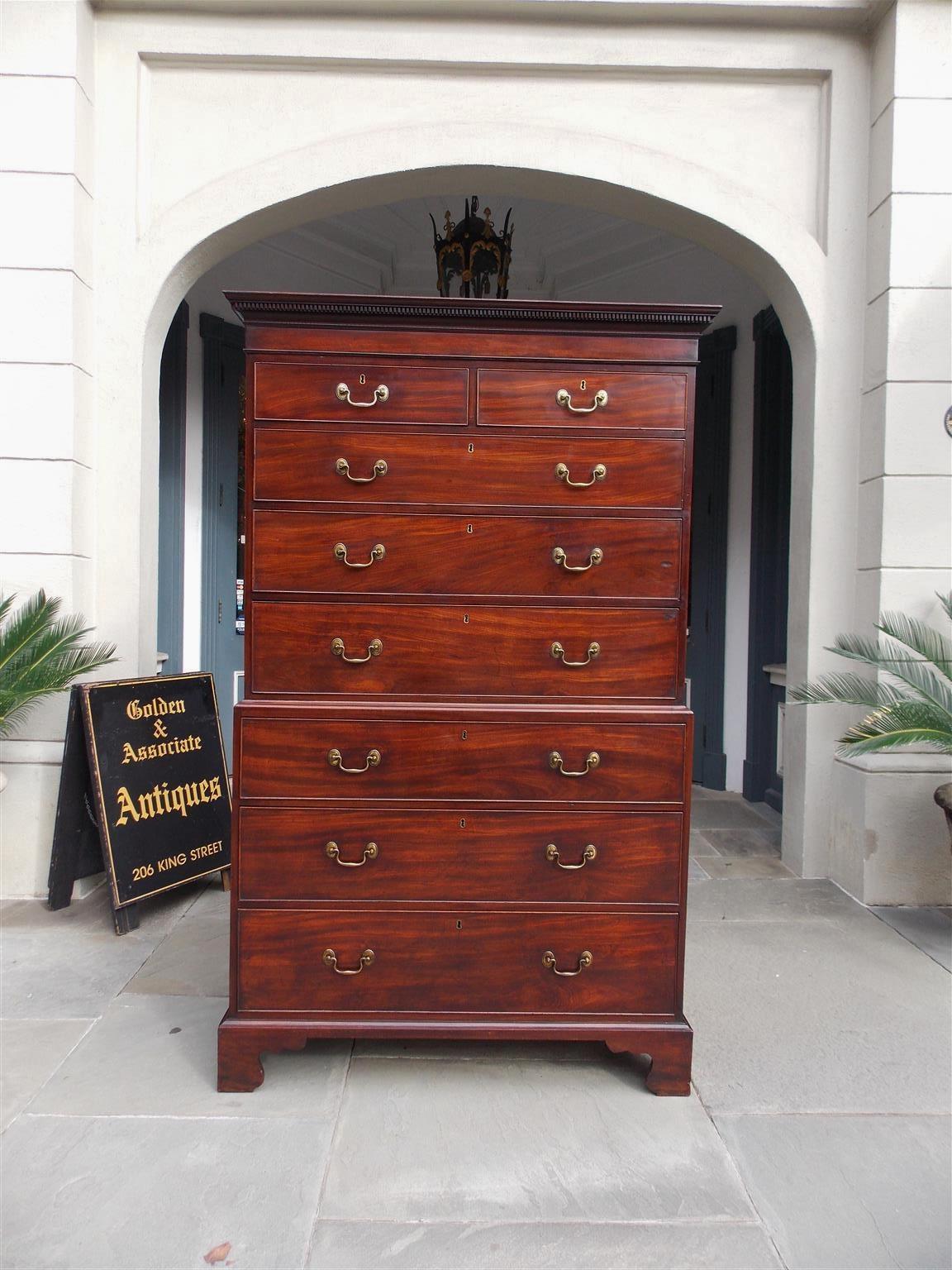 American Chippendale mahogany chest on chest with a carved dentil molded edge cornice, graduated upper and lower case drawers with the original brasses, and resting on the original carved molded scalloped bracket feet. Late 18th Century. Secondary