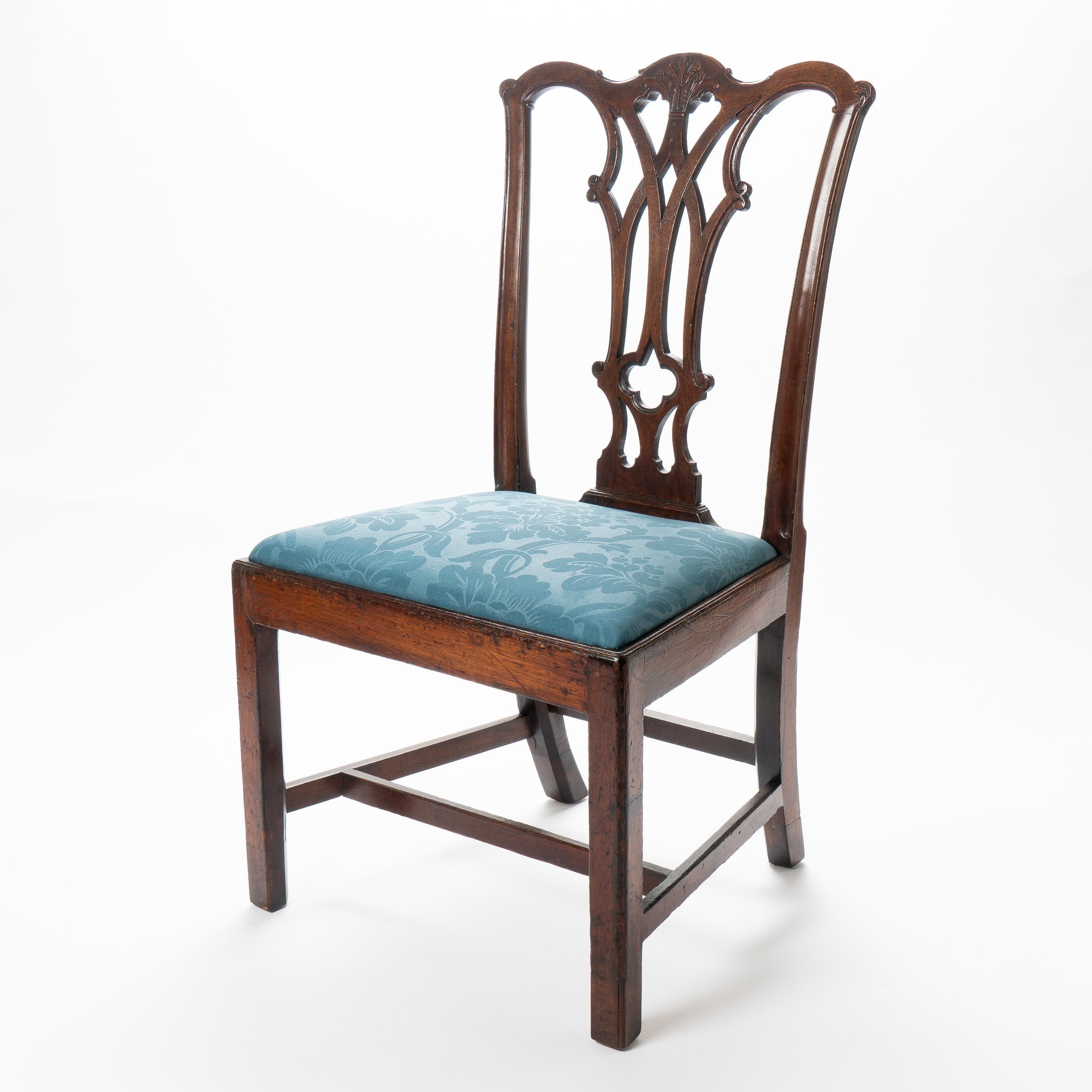 American Chippendale mahogany slip seat side chair by Thomas Tuft (1740–1788) with rococo carved detail on the center crest rail above a pierced back splat. The chair rests on square legs joined by an “H” stretcher, and the slip seat is upholstered