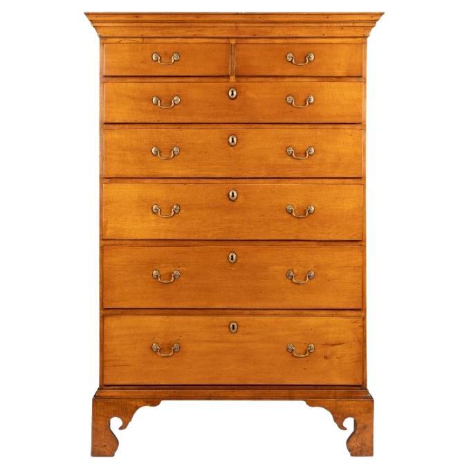 American Chippendale maple tray top tall chest with divided top drawer. The chest is mounted with a cornice and rests on bracket feet. The drawers are lap front and fitted with replacement cast brass rosette and swan neck drawer pulls in the
