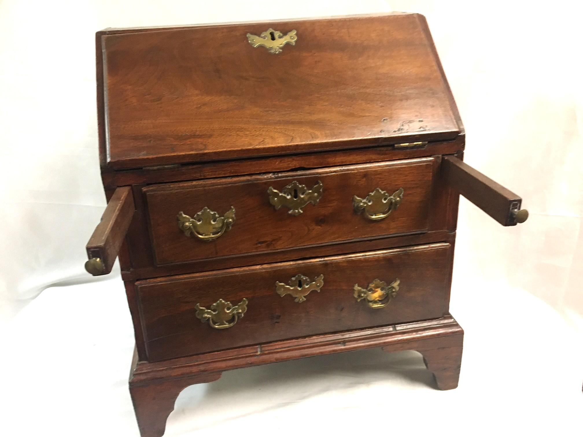 Ce rare et important bureau à plateau incliné est un exemple exceptionnel de meuble miniature. Présentant toutes les caractéristiques souhaitables d'un Chippendale, ce bureau comporte deux tiroirs à queue d'aronde, le tiroir supérieur étant un peu