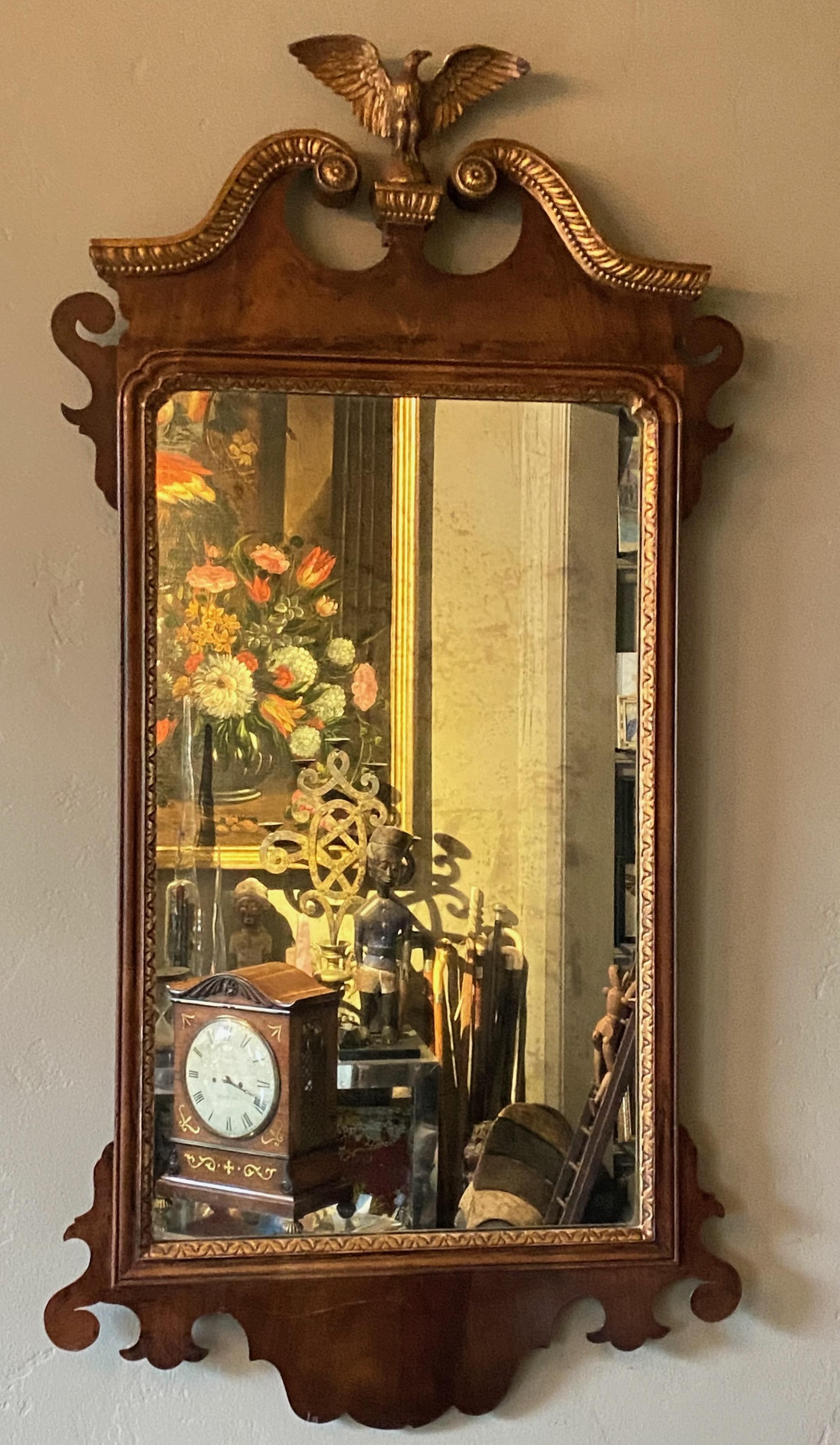 A classic American Chippendale style mahogany mirror with aged glass mirror and gilt detail.
American, early 19th century.