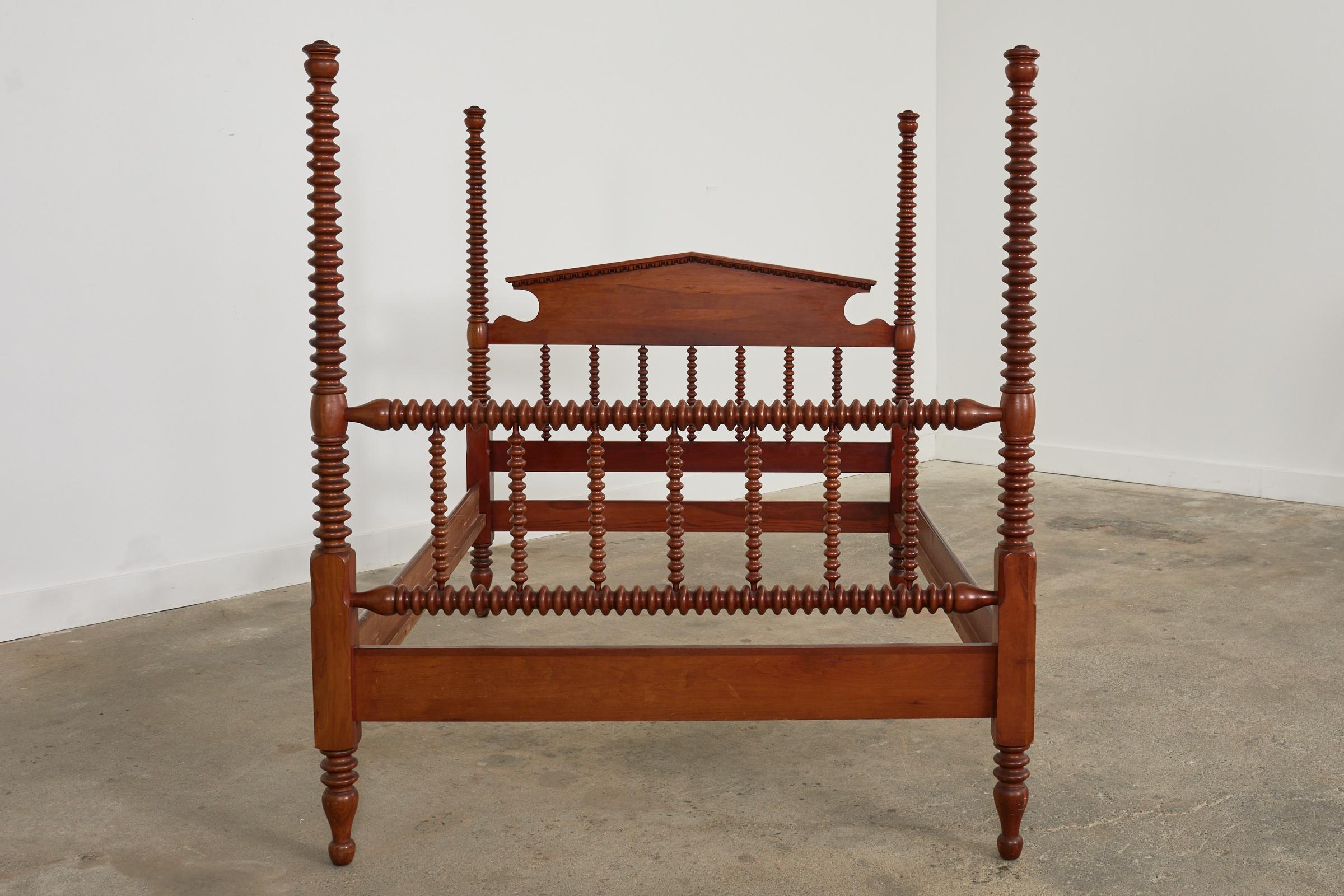 Impressive American classical spindle bed crafted from fruitwood. The bed features exaggerated tall bobbin or spool turned bed posts that give the bed a dramatic profile. The set includes a headboard, footboard, and two rails. The headboard has an