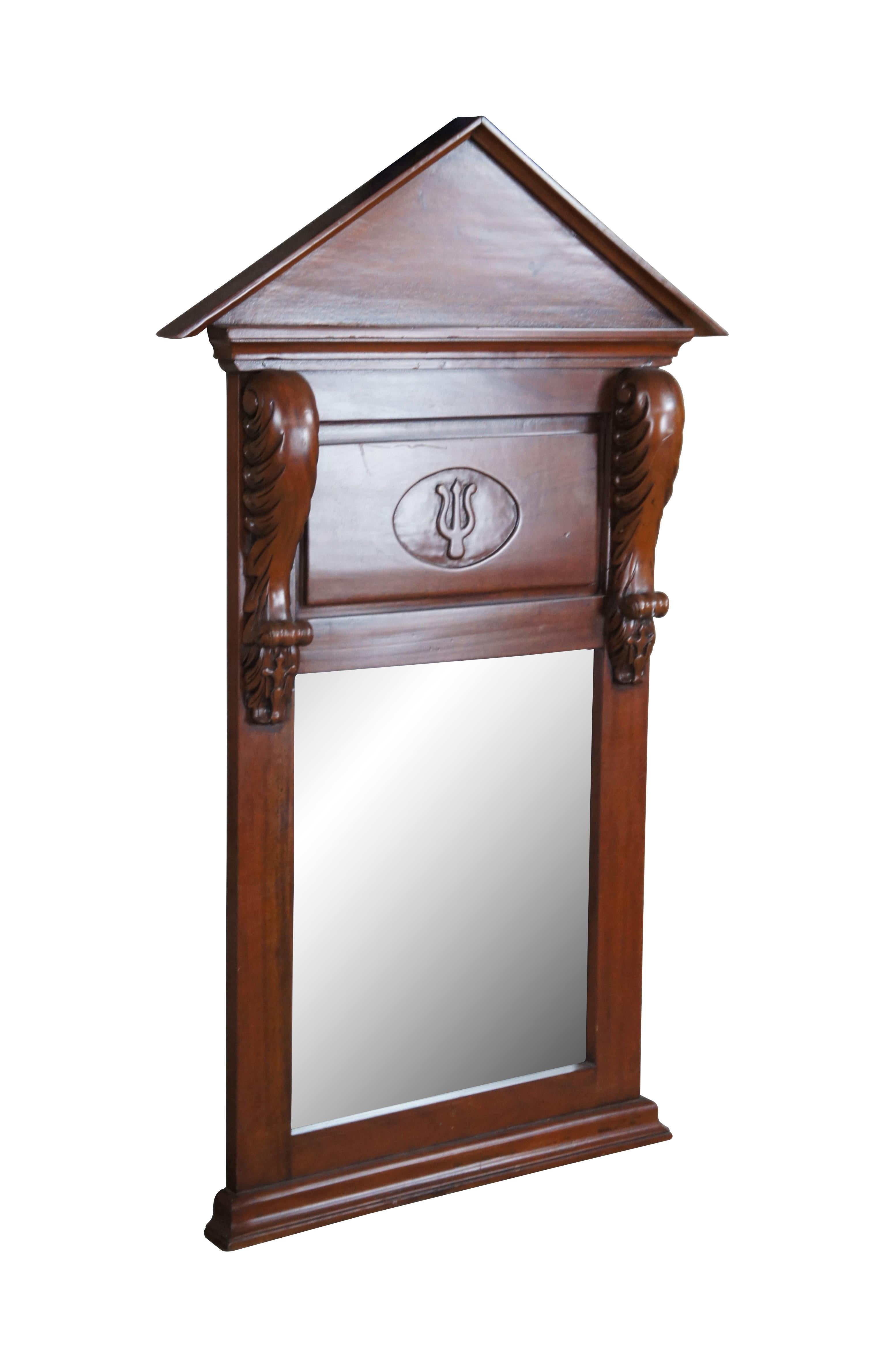 Miroir à fronton de style Empire classique américain, vers le dernier quart du 20e siècle. Cadre en acajou avec fronton arqué et écoinçons sculptés d'acanthes autour d'un panneau en forme de trident et d'un miroir en verre biseauté. S'accroche à