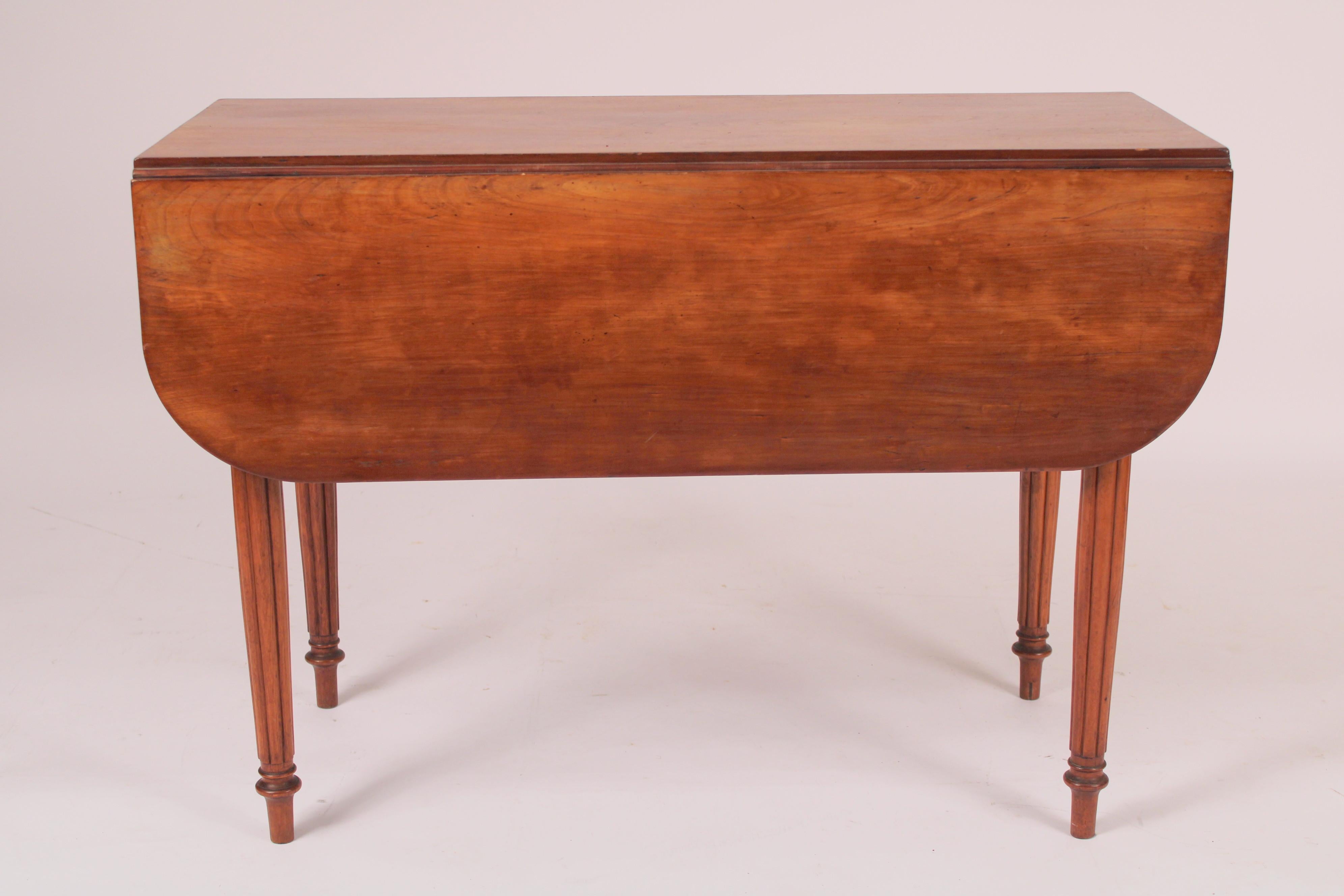 American cherry wood drop leaf table, early 19th century. With two drop leafs, one drawer, resting on reeded legs. The cherry wood has nice old color. Very functional table that could be used as extra dining, games table or folded down as a sofa