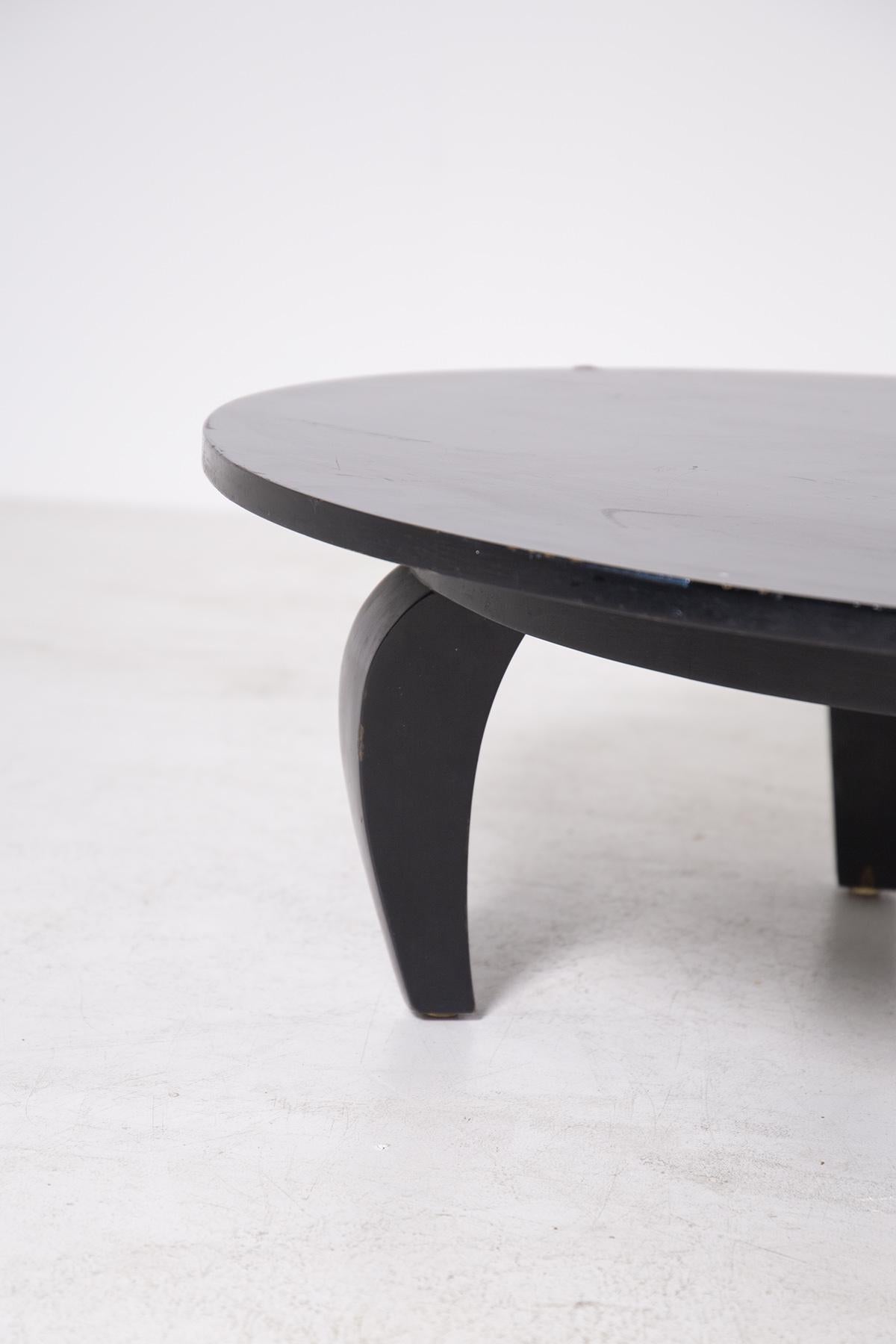 Elegant American-made coffee table from the 1950s. 
The table is made of wood painted black. The table top is oval with curved wooden feet. The table is ideal for designer living rooms with an American feel. Given its size, it is also ideal for