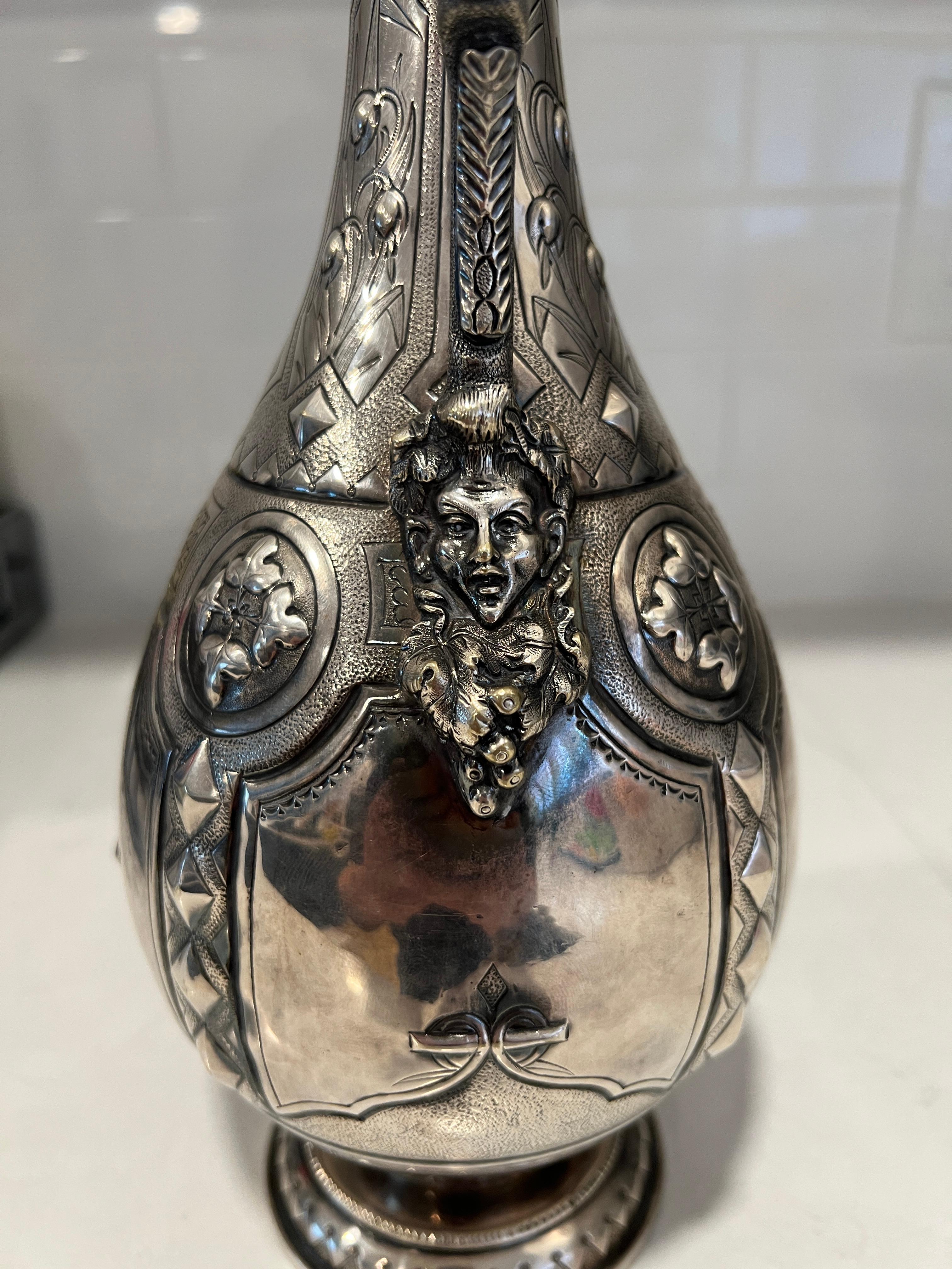American, circa 1875. 

An impressively detailed and hand crafted American coin silver ewer or pitcher featuring a beautiful nude figural female with sculpted foliate detail handle morphing into a classical mask on the body. A hand hammered surface,