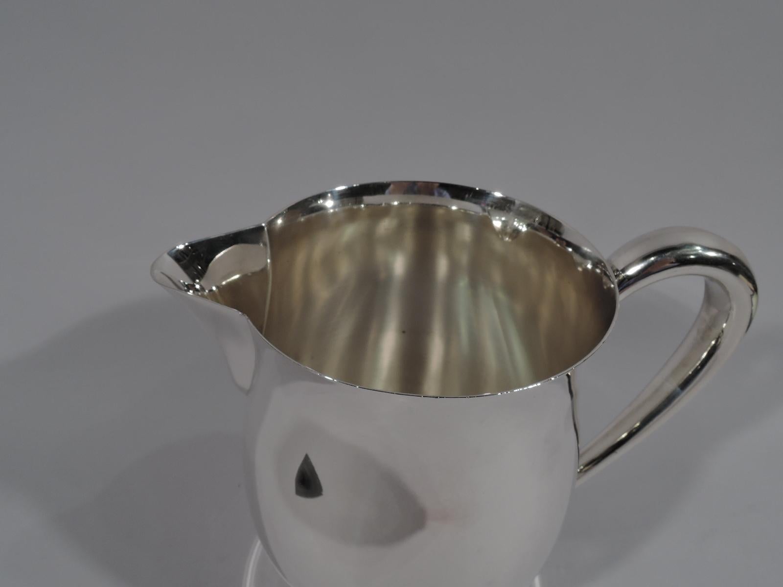 Colonial Revival sterling silver water pitcher. Made by International in Meriden, Conn., circa 1950. Gentle baluster with high-looping handle and V-spout. Traditional form compatible with a Modern table setting. Holds 4 pints. Fully marked including