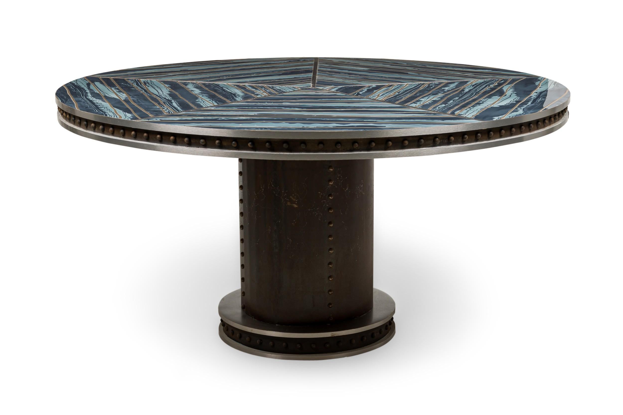 Table ronde de salle à manger AM Contemporary à plateau segmenté en faux marbre bleu reposant sur un socle en métal riveté de style Brutalist à roulettes cachées.