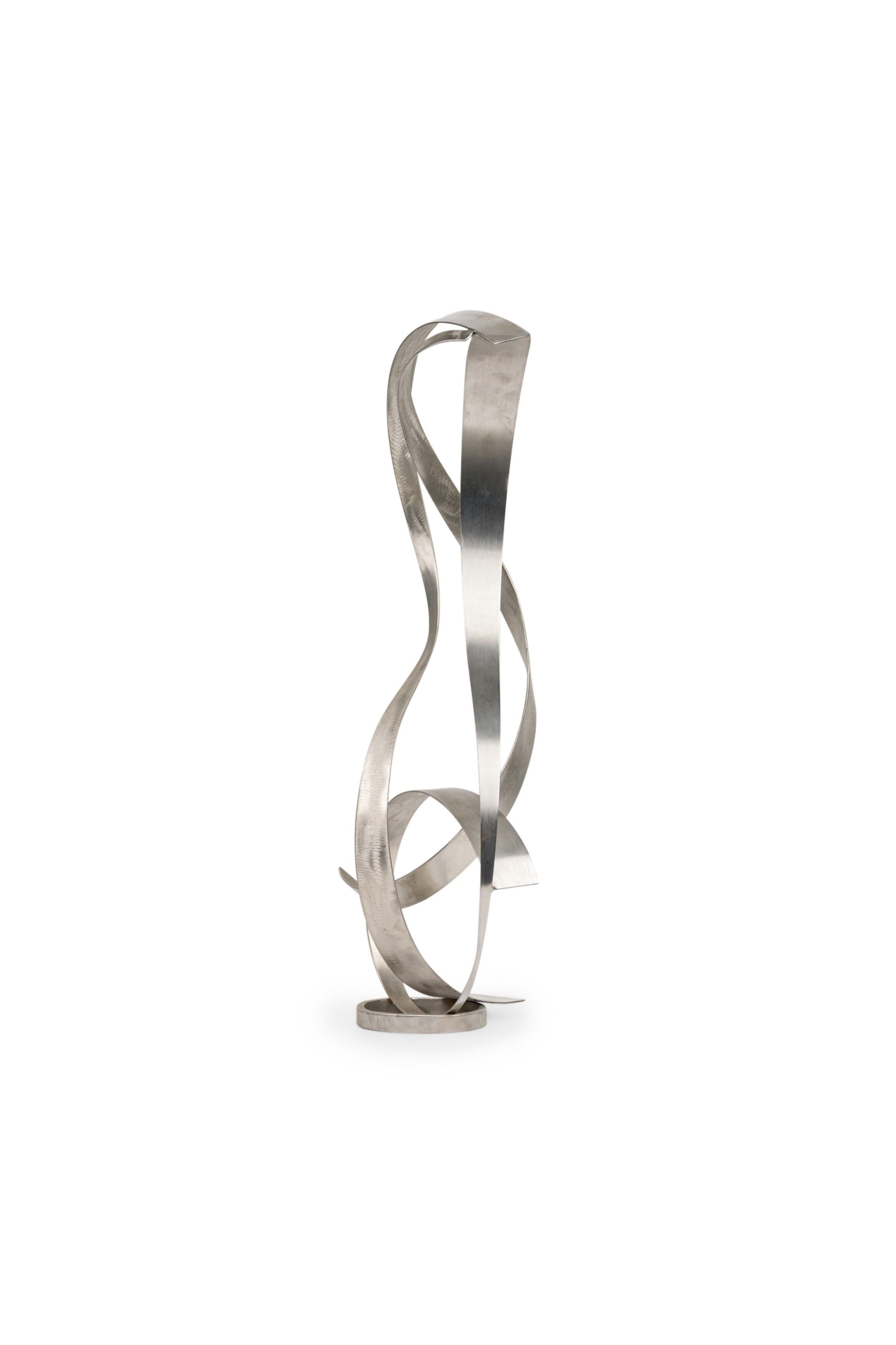 Scultura contemporanea americana con 3 lastre di metallo che si attorcigliano tra loro in un disegno a spirale e che poggiano su una piccola base circolare.