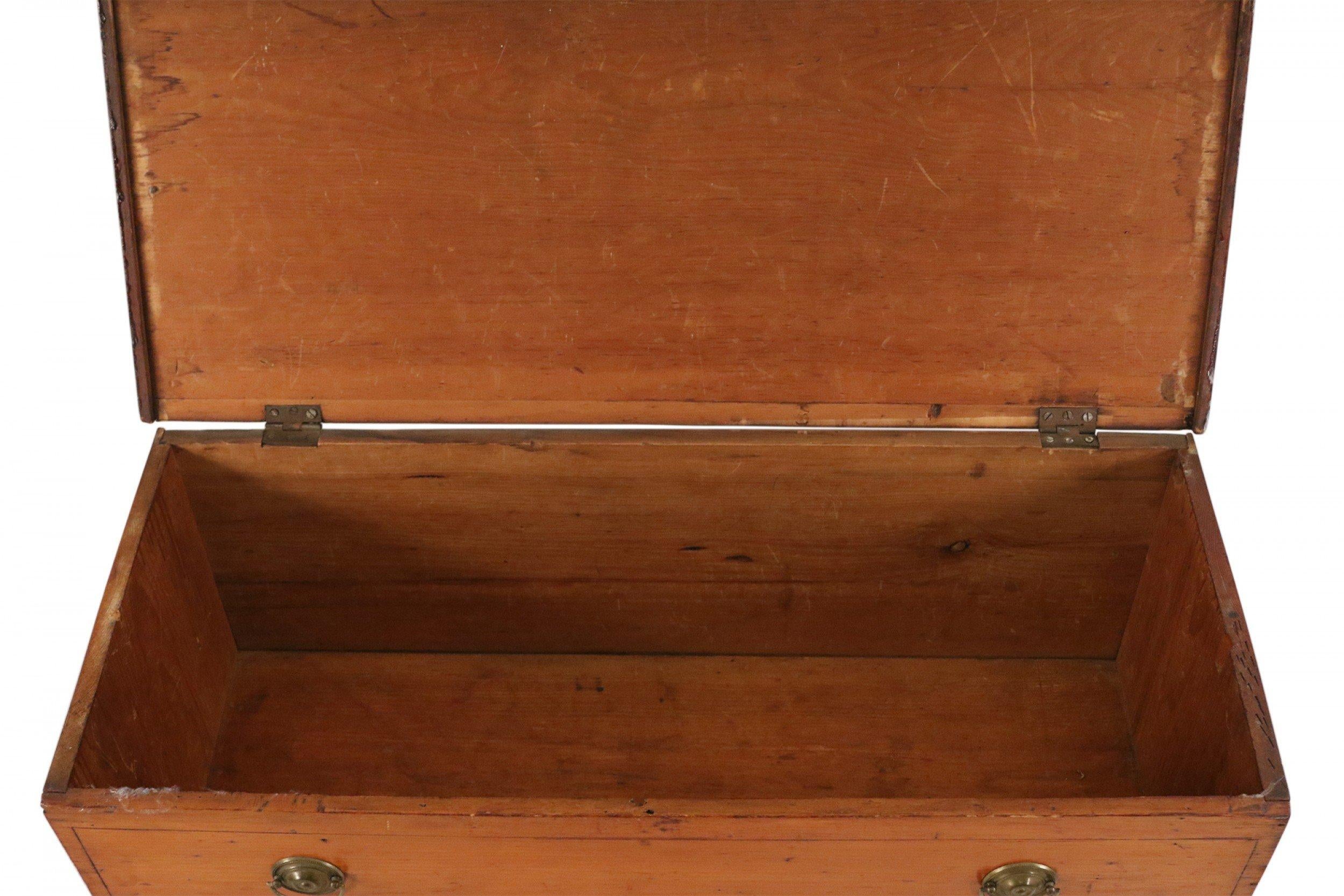 American Country (Mid-Century) four drawer stained pine dresser with oval brass drawer pulls and a hinged top that opens into a storage compartment.
 