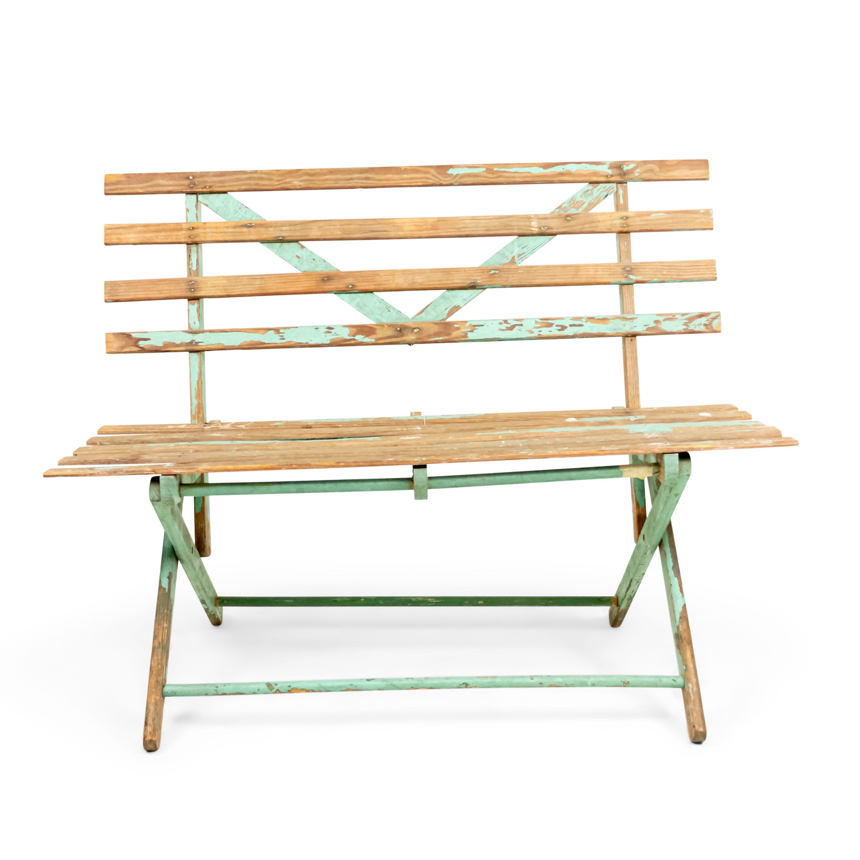 American Country style (19/20th century) outdoor folding bench with a weathered green painted slat design seat and back.
     