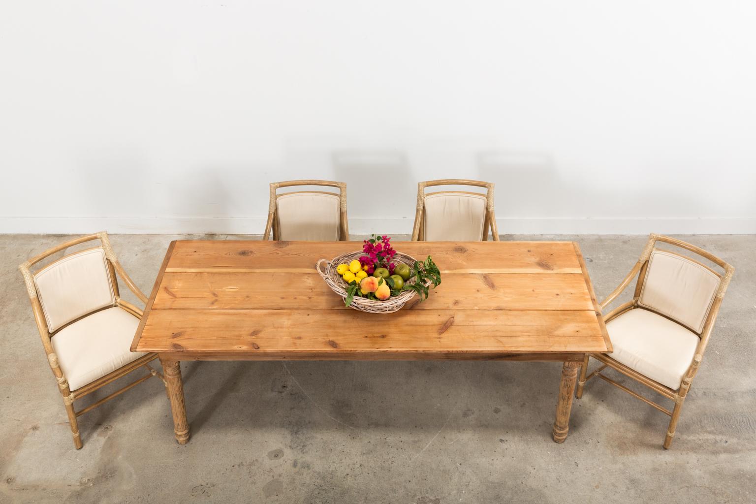 Charming American country farmhouse dining table crafted from reclaimed pine with a beautifully aged patina. The top is made from three wide planks having breadboard ends and a natural finish. The base is supported by thick, turned legs that are