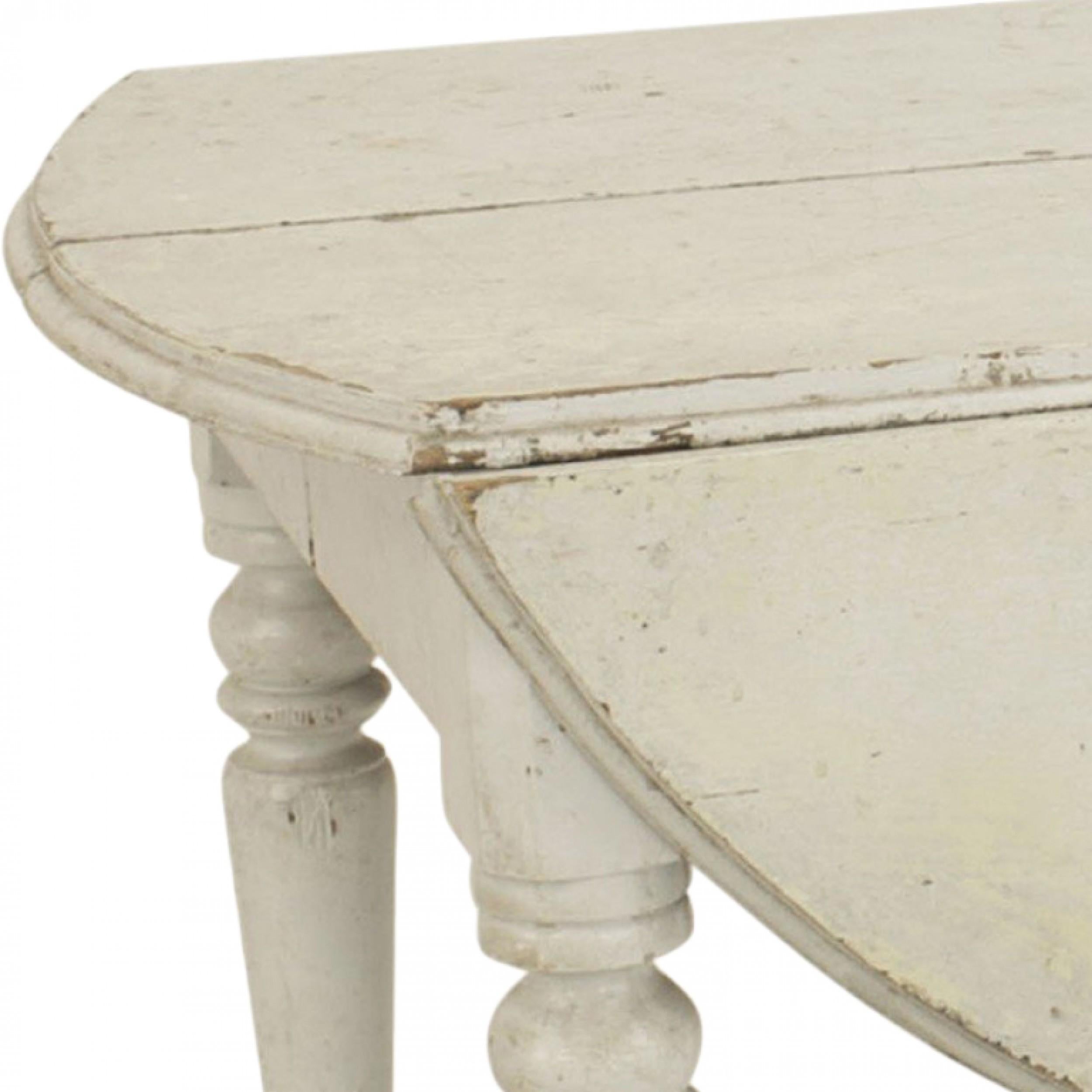 American Country Mid-Century white painted over oak drop leaf dining table on 4 turned legs with a 5th center leg. (Drop leaf 11.5