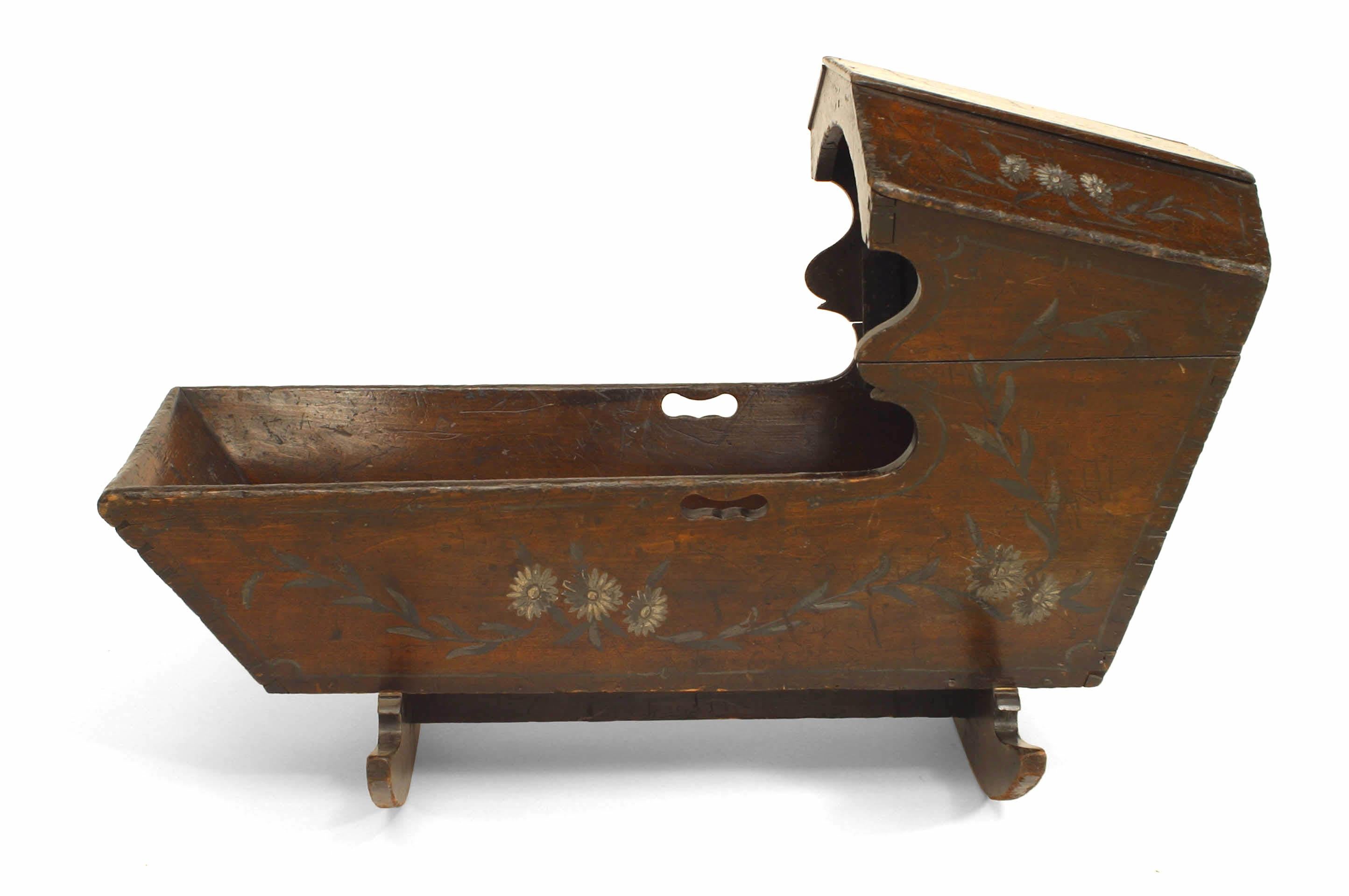 American Country style (19th Cent) stained pine rocking cradle with floral-decorated hood.
