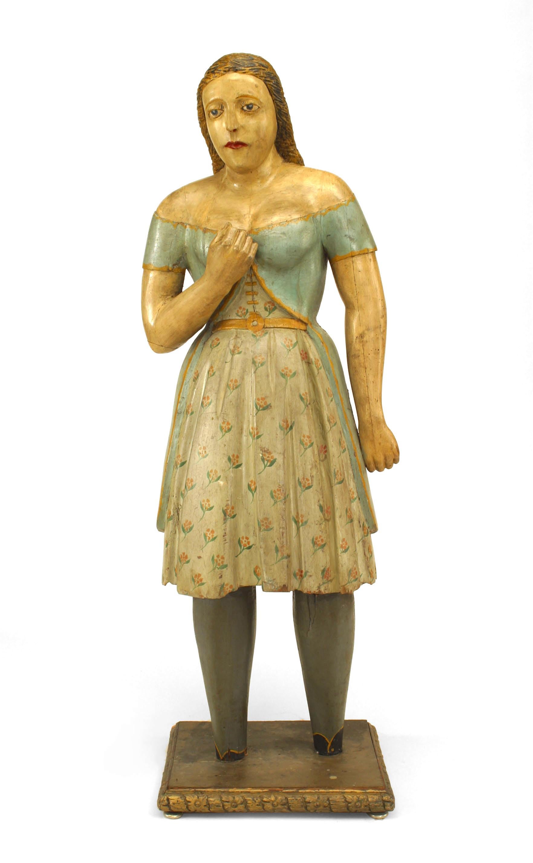 American Country style life size wood figure of young girl with light blue and floral decorated dress. (19th Cent.)
