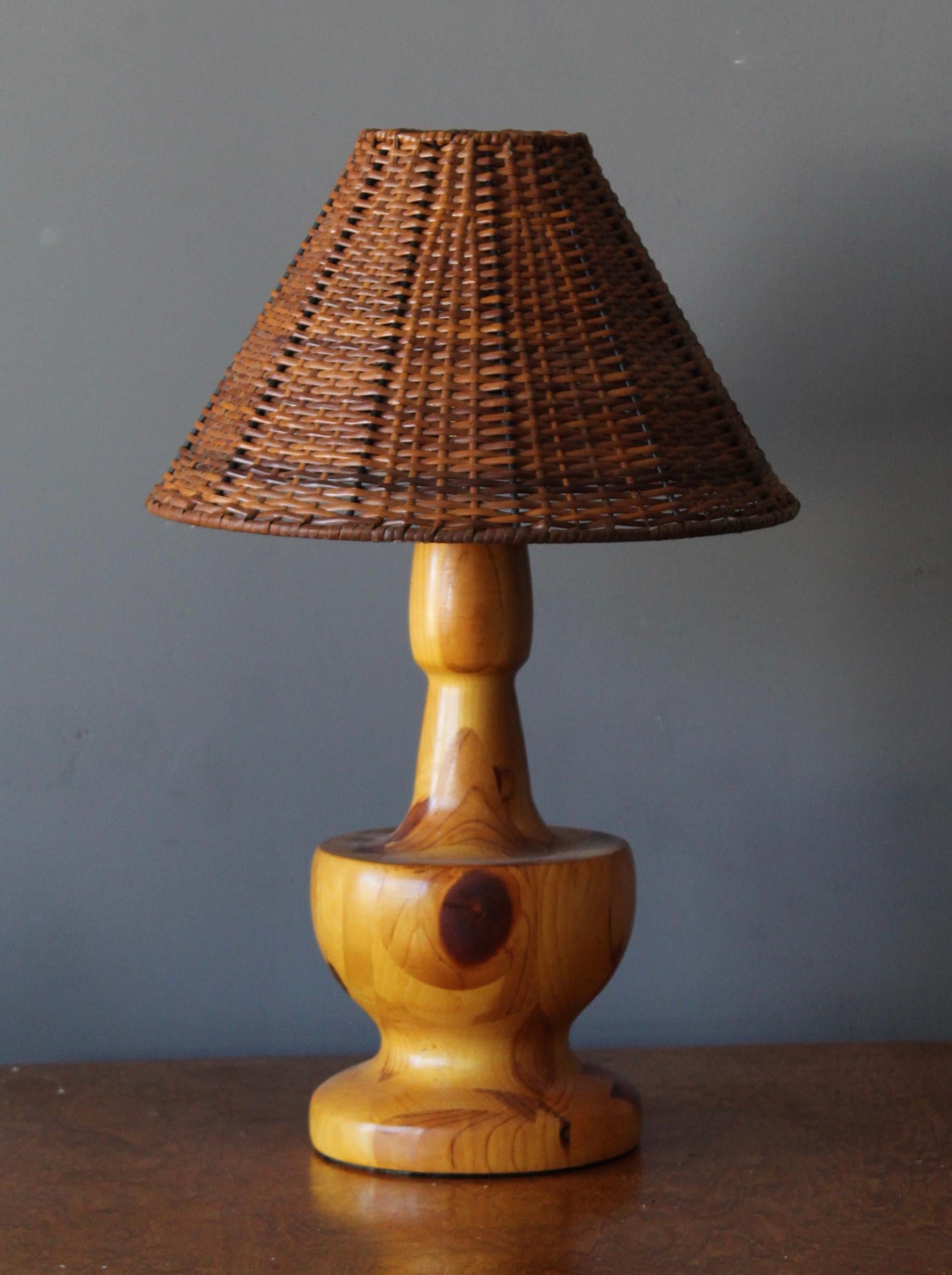 A large table lamp. In turned solid pine. By unknown studio craftsman. With assorted vintage rattan lampshade.

Stated dimensions include lampshade.

Other designers of the period include Alexandre Knoll, George Nakashima, Isamu Noguchi, J.B.