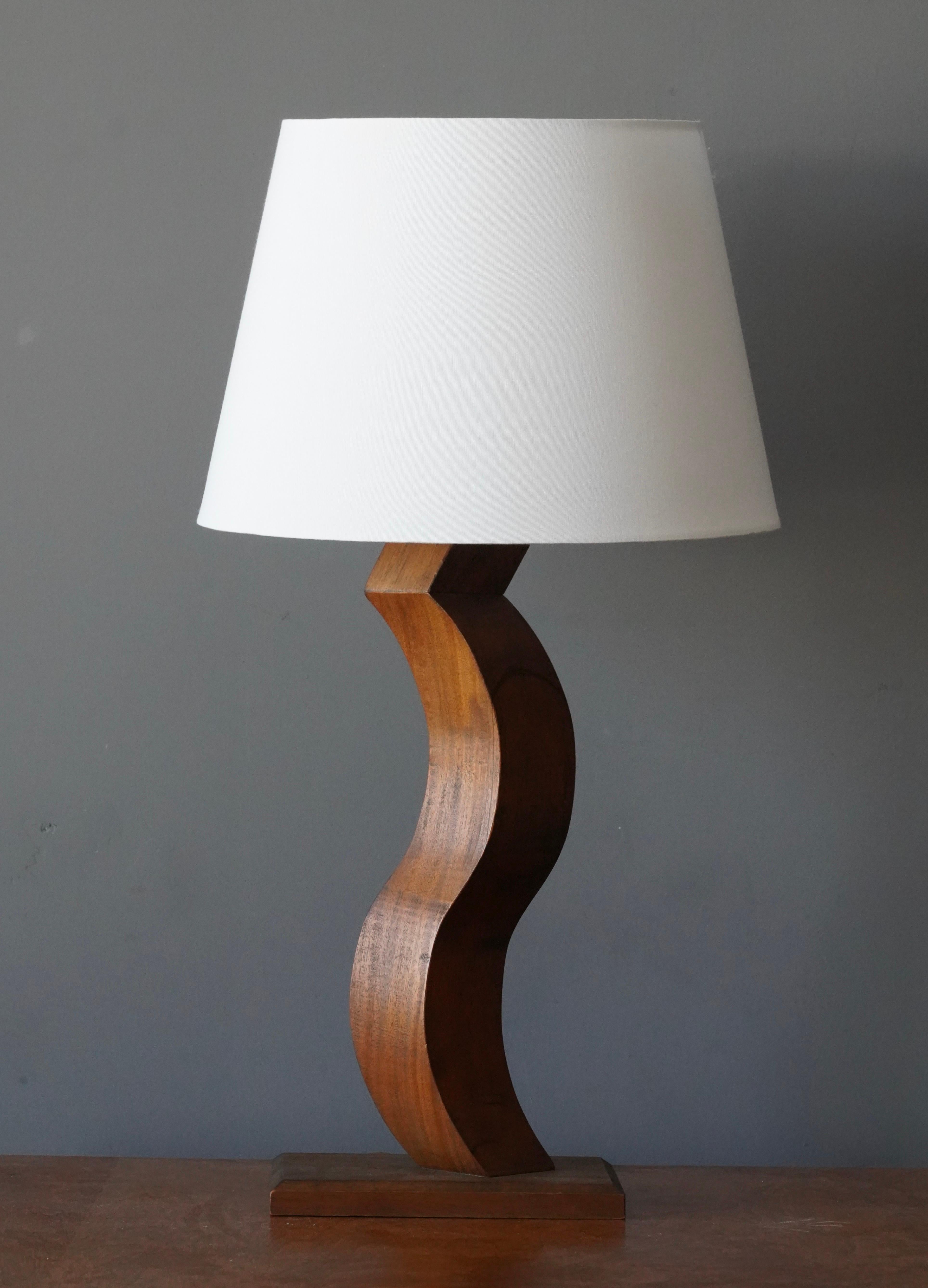 A table lamp. In finely carved and stained oak in abstract form. Designed and produced by unknown studio craftsman. Presents with beautiful original patina to wood and brass.

Sold without lampshade, stated dimensions excluding lampshade,

Takes