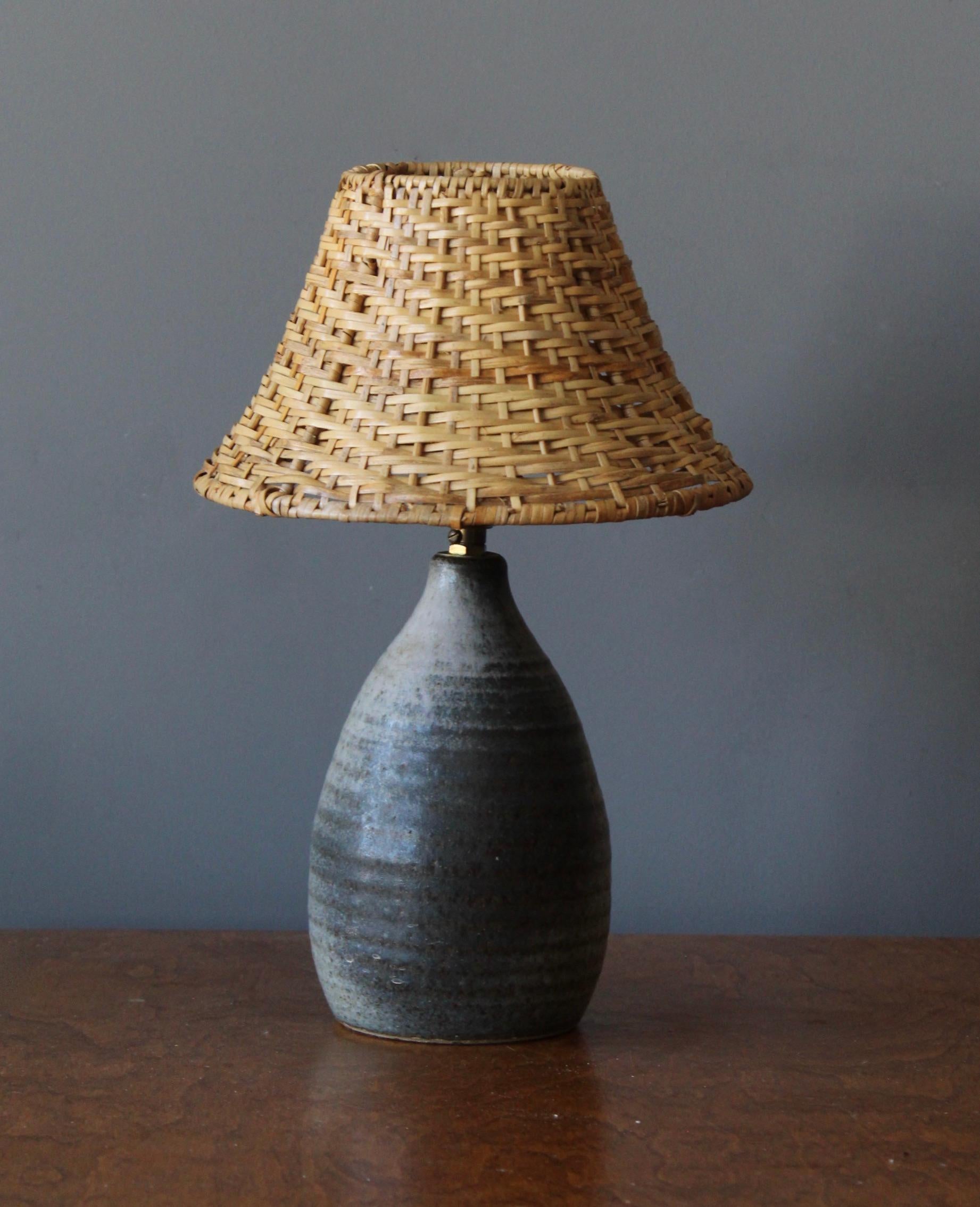 A table lamp. In ceramic, brass. By unknown studio craftsman. With assorted vintage rattan lampshade.

Stated dimensions include lampshade.

Other designers of the period include Alexandre Knoll, George Nakashima, Isamu Noguchi, J.B. Blunk and