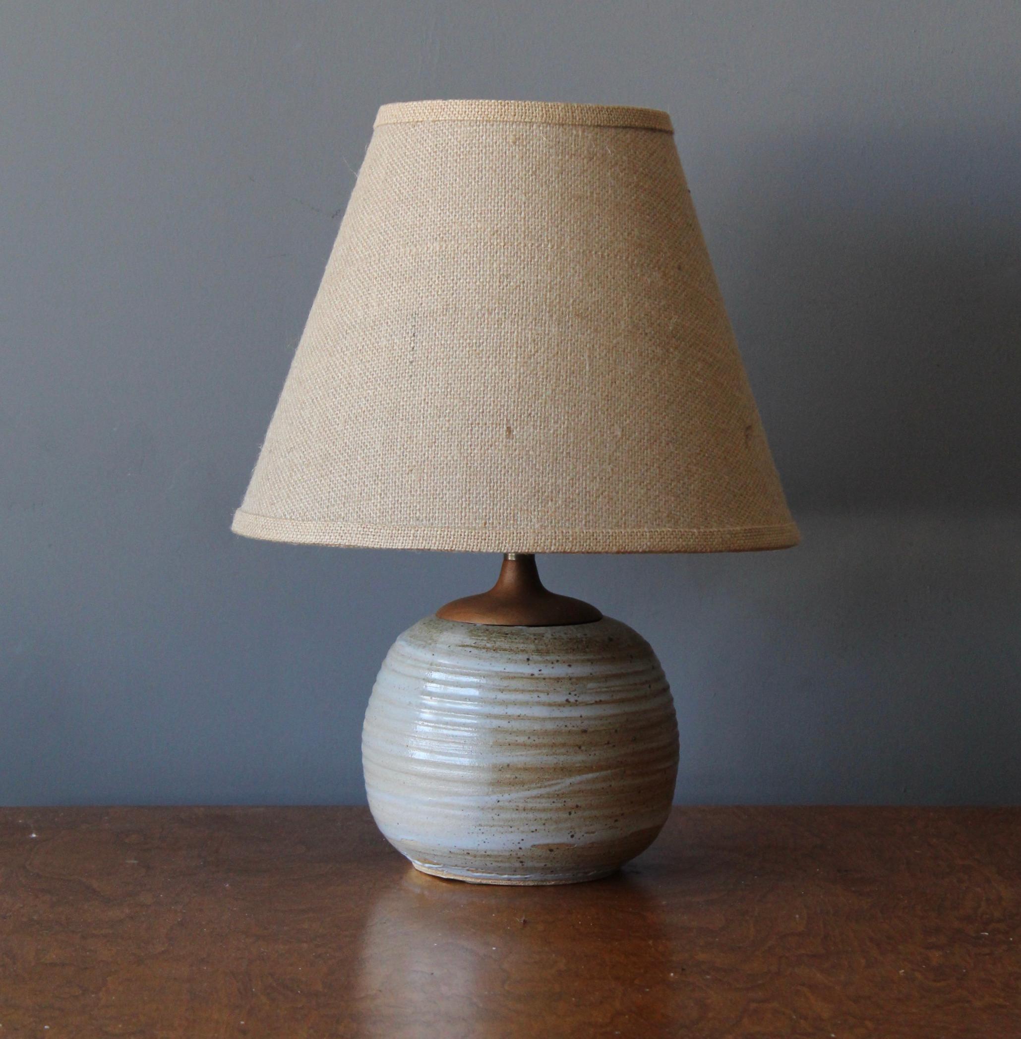 A table lamp. In ceramic, teak and brass. By unknown studio craftsman. 

Stated dimensions exclude lampshade. Height includes socket. Sold without lampshade.

Other designers of the period include Alexandre Knoll, George Nakashima, Isamu