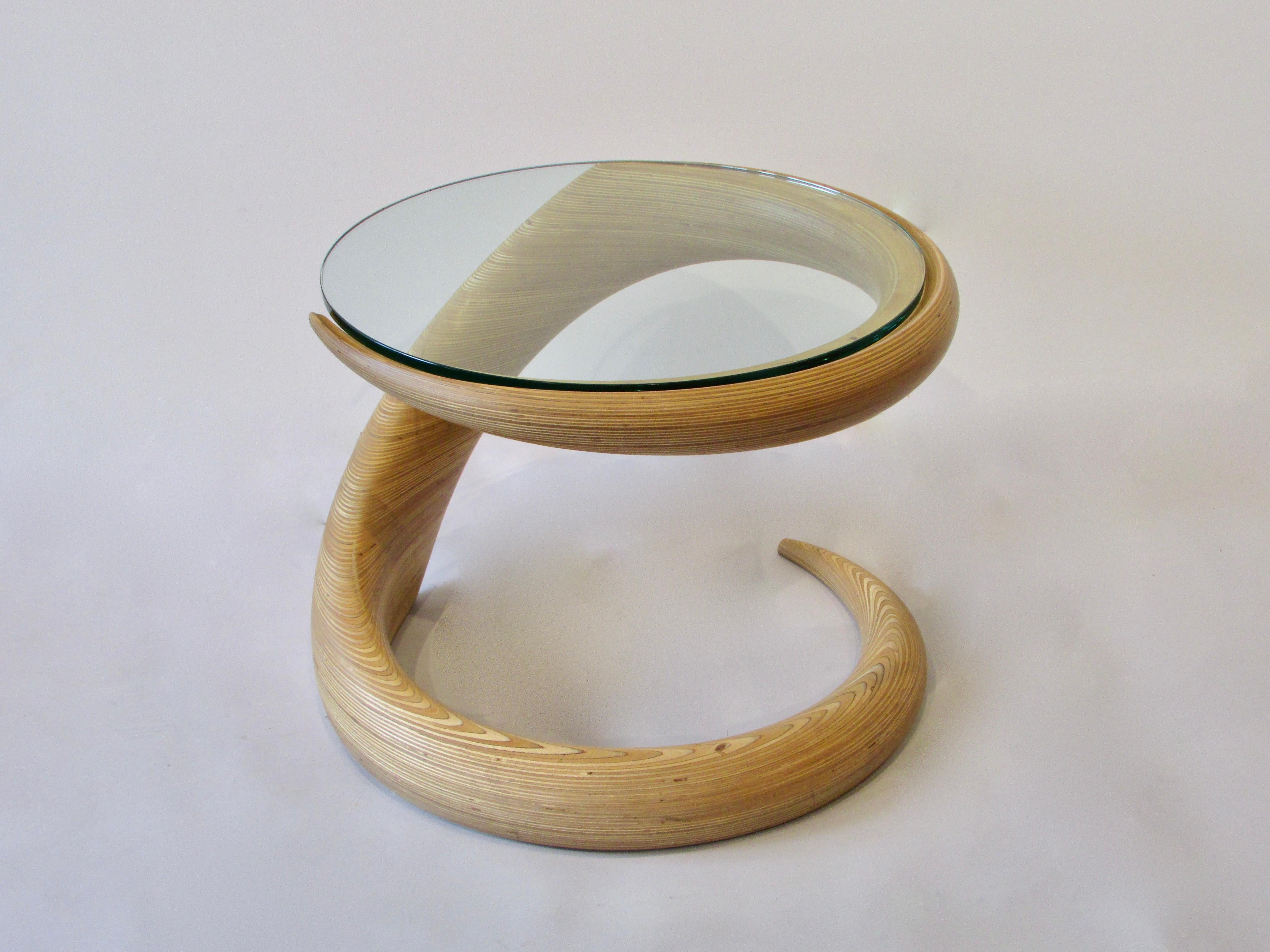 American craft movement table of stacked laminate. Beautifully sculpted into a fluid form supporting round glass top. Possibly incomplete signature shows as Rock Goss 85 and a copyright 