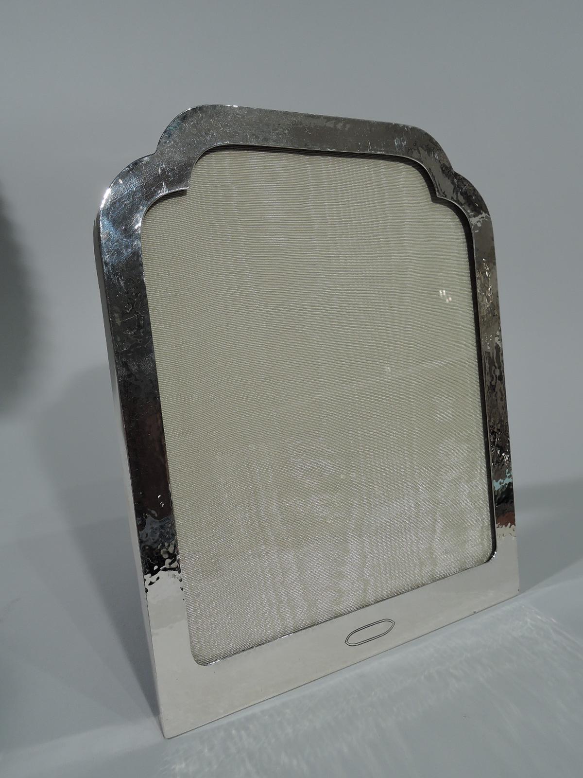 Craftsman sterling silver picture frame. Made by Watrous (a division of International) in Wallingford, Conn., circa 1920. Flat and rectangular surround with arched trefoil top. Shaped tubular cartouche (vacant) at bottom. Visible hand hammering.