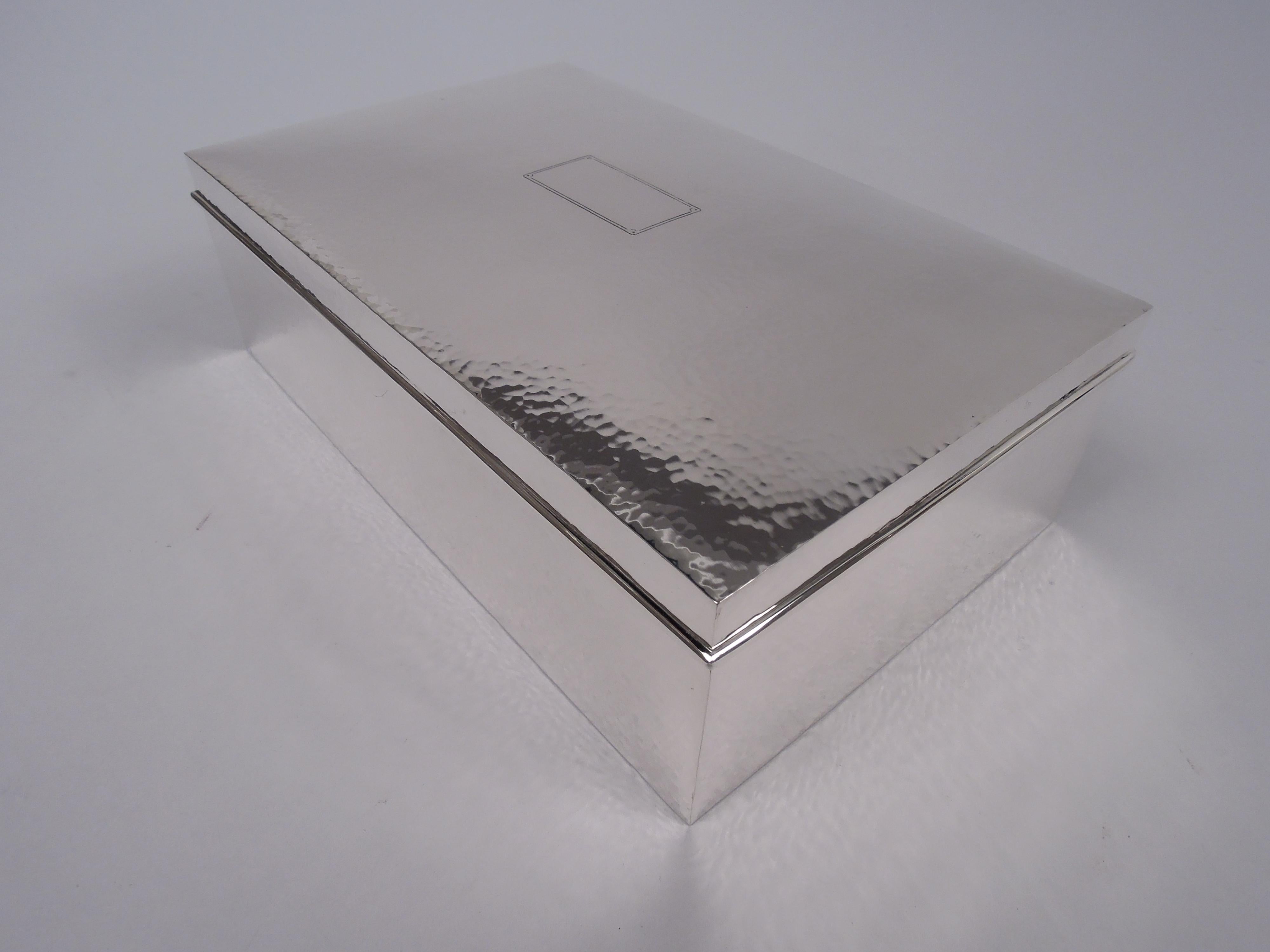 Caja artesanal de plata de ley. Fabricado por Ahrendt & Kautzman en Newark, hacia 1920. Rectangular con lados rectos. Tapa abatible con parte superior suavemente curvada y borde moldeado. Martilleo puntual en toda la superficie. La tapa superior