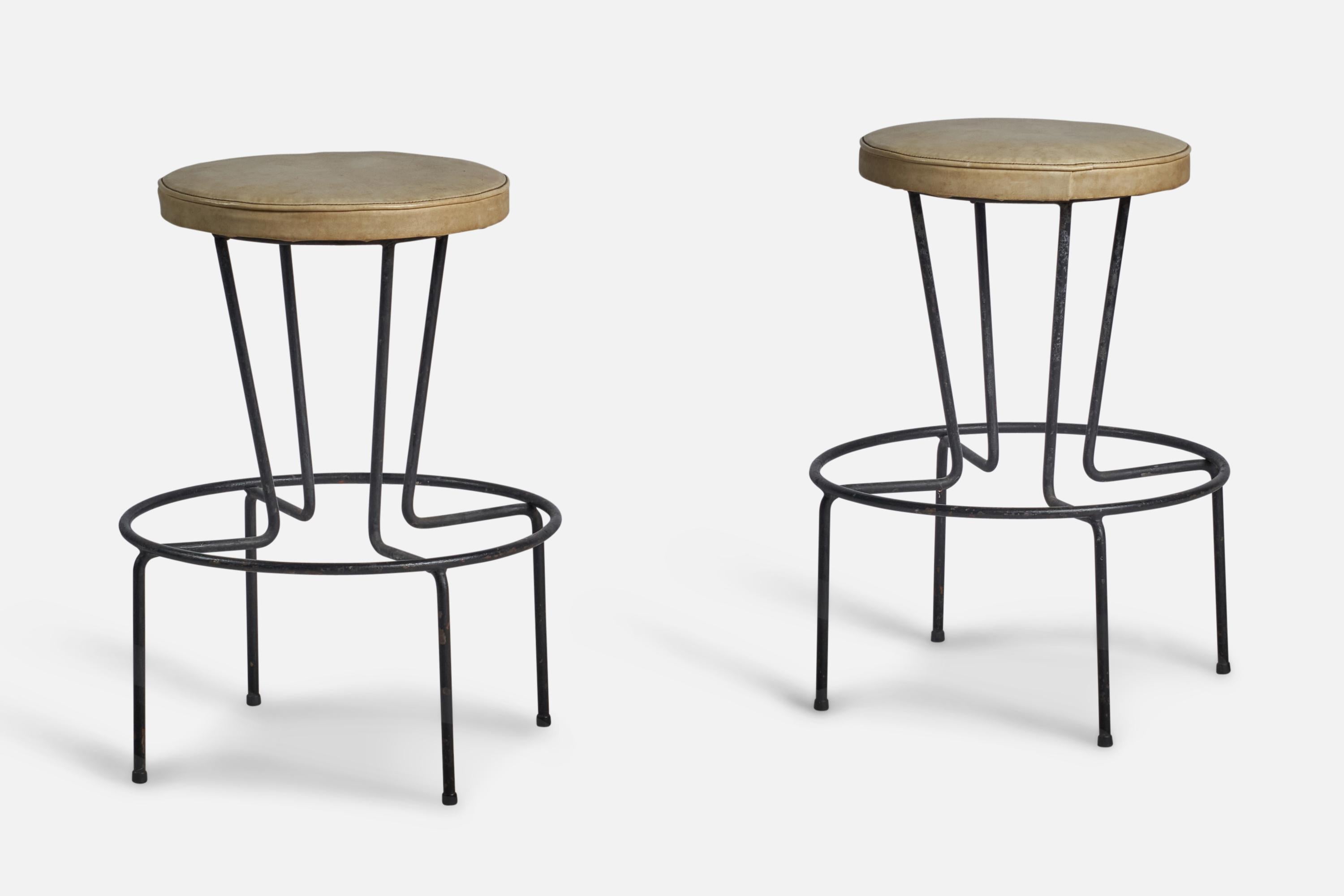 A pair of black-lacquered metal and beige leather stools designed and produced in the US, 1950s.
