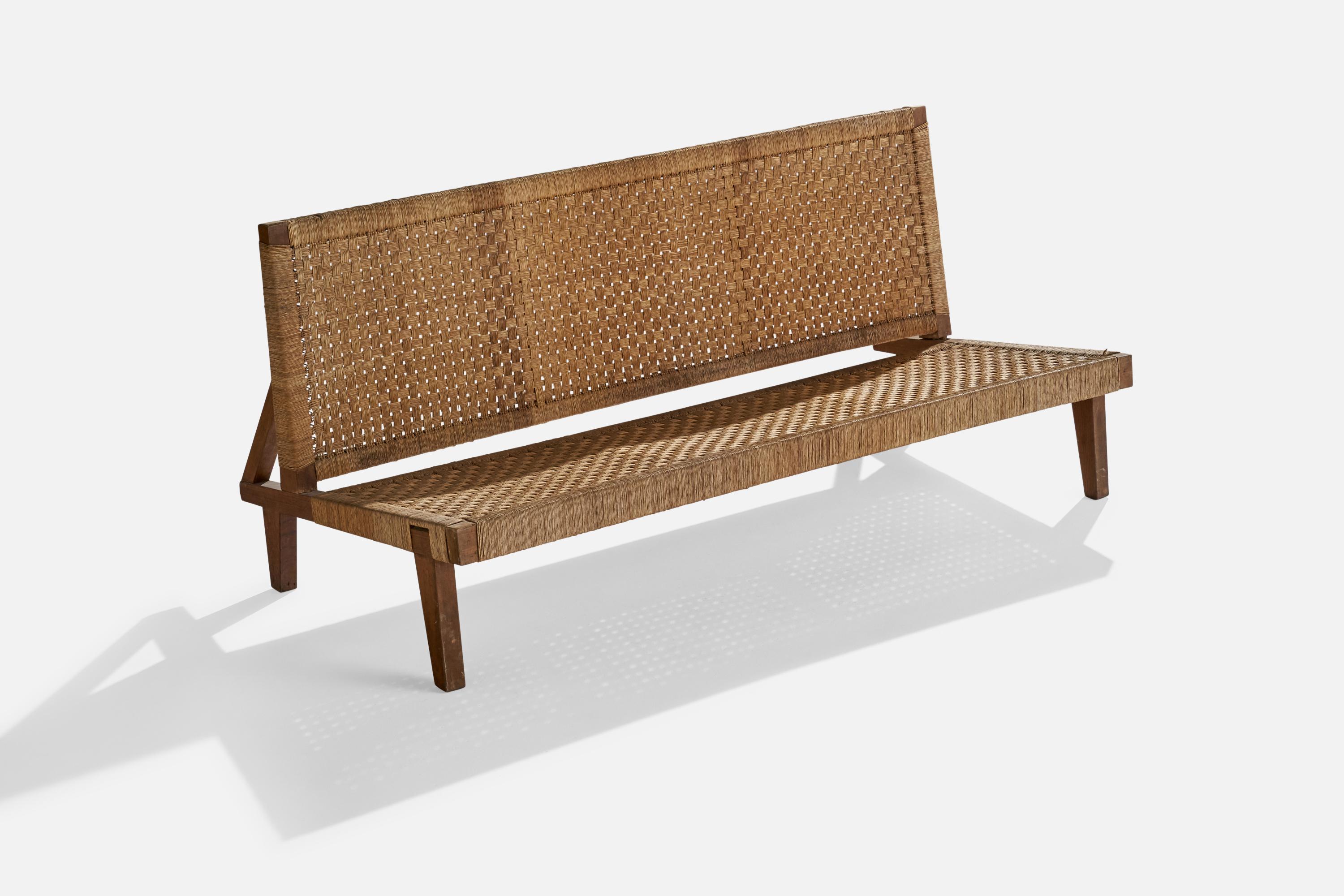 A walnut and rattan bench designed and produced in the US, 1950s.

seat height 14”.