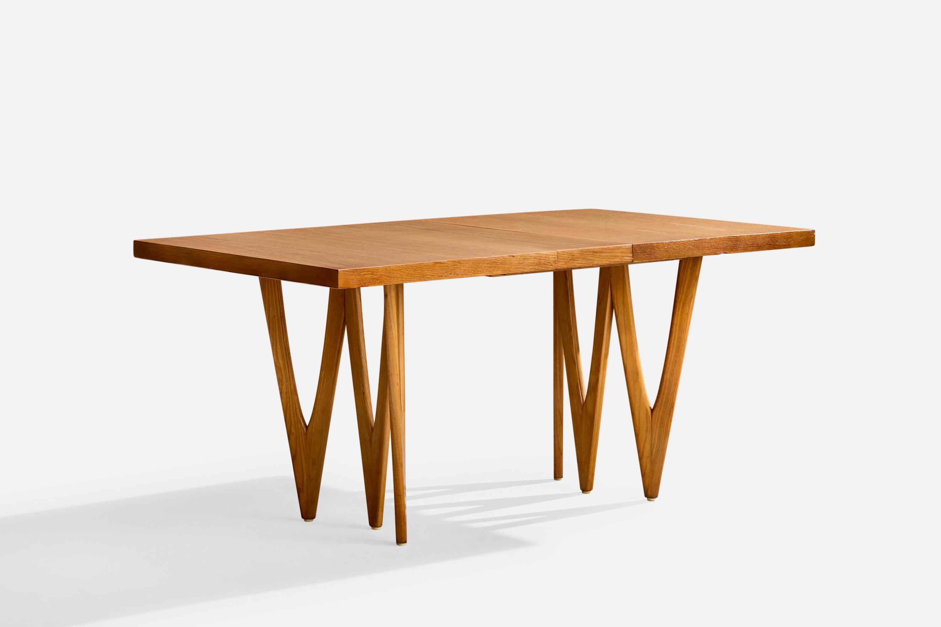 An extendable oak and walnut dining table designed and produced in the US, c. 1950s.

Overall Dimensions (inches): 29.2