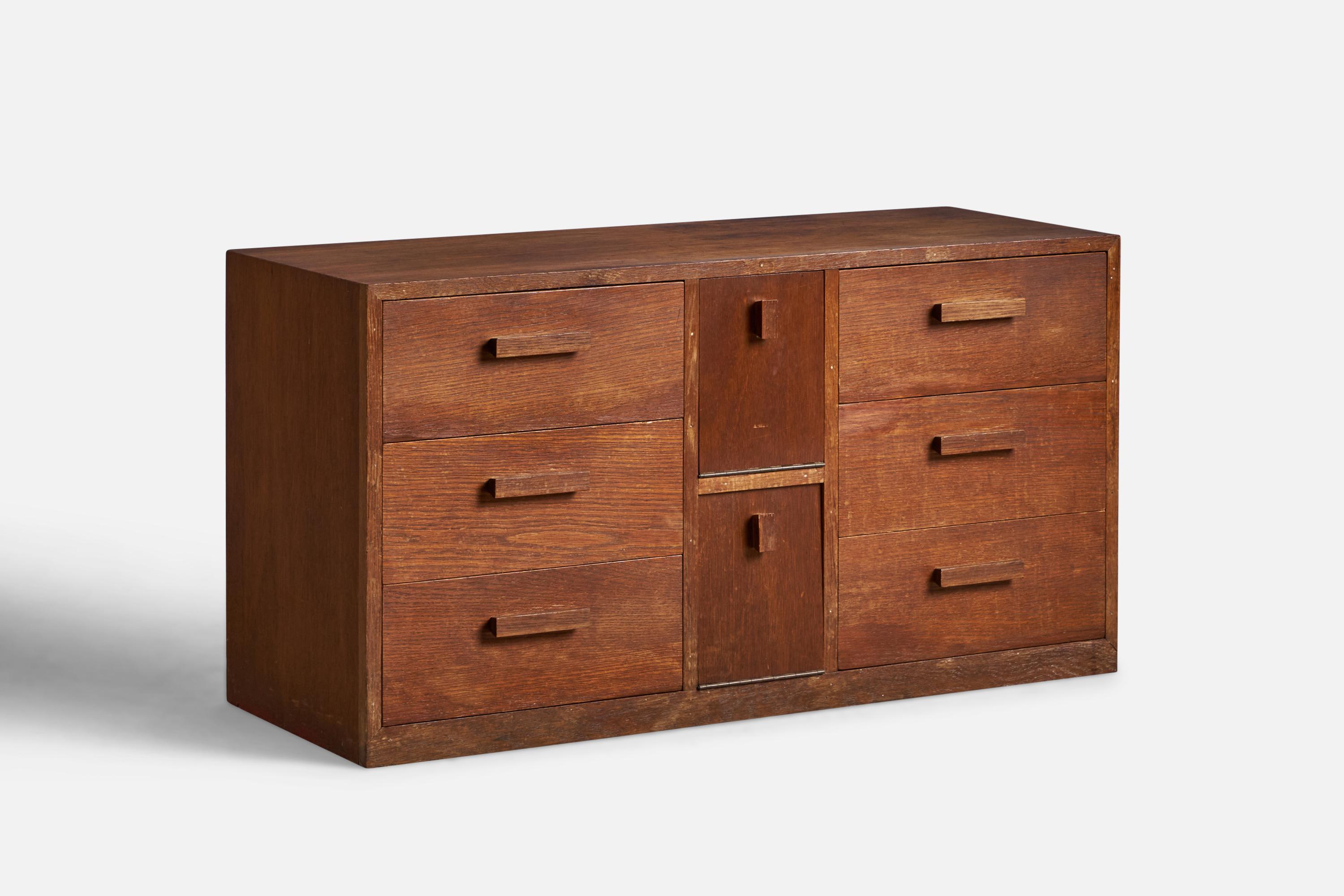 A dark-stained oak dresser designed and produced in the US, 1940s.