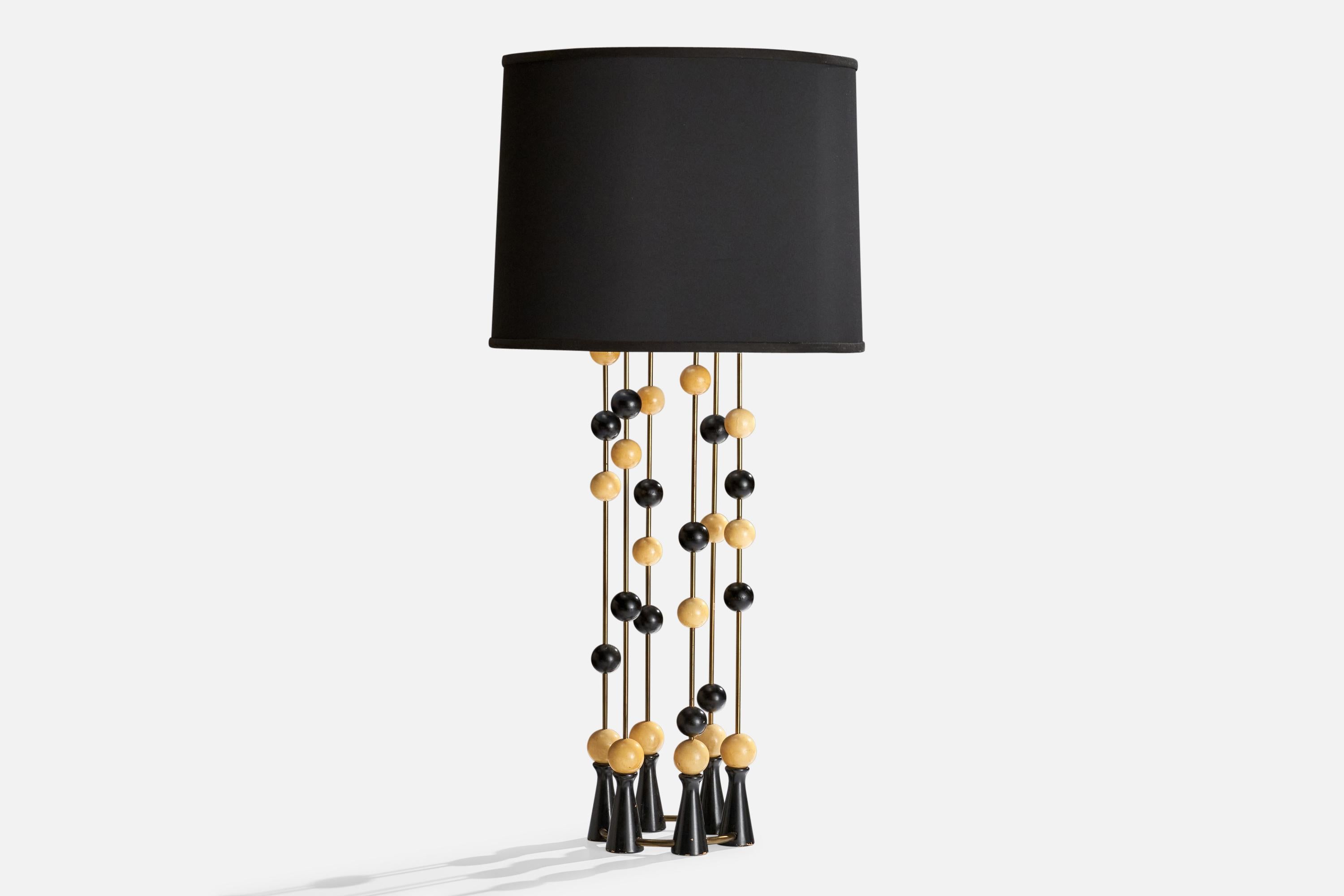A large brass, black-lacquered wood and black fabric table lamp designed and produced in the US, c. 1950s.

Lampshade replaced at some point in recent history.

Dimensions of Lamp (inches): 35.25” H x 8.5” W x 8.5” D

Dimensions of Shade (inches):