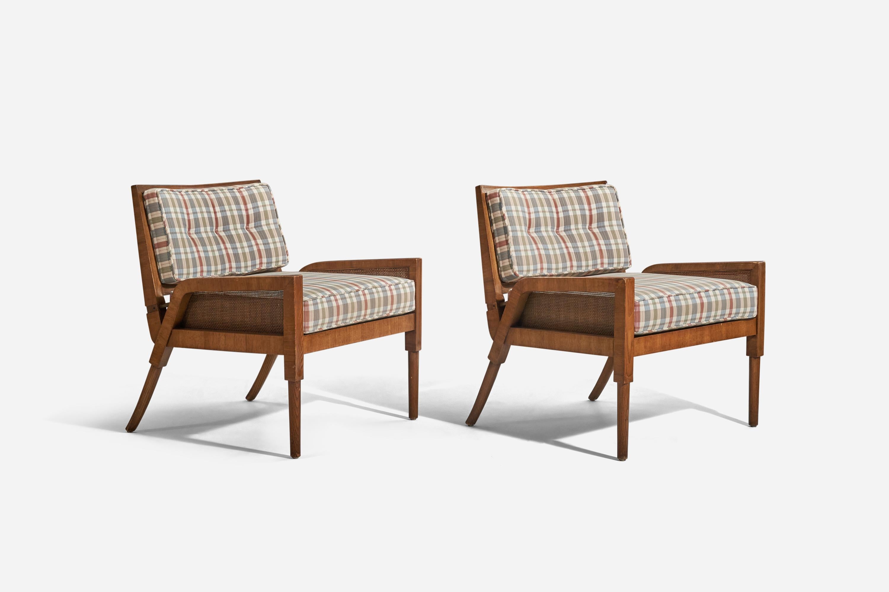 A pair of oak, fabric and cane lounge chairs designed and produced by an American designer, United States, 1950s.




