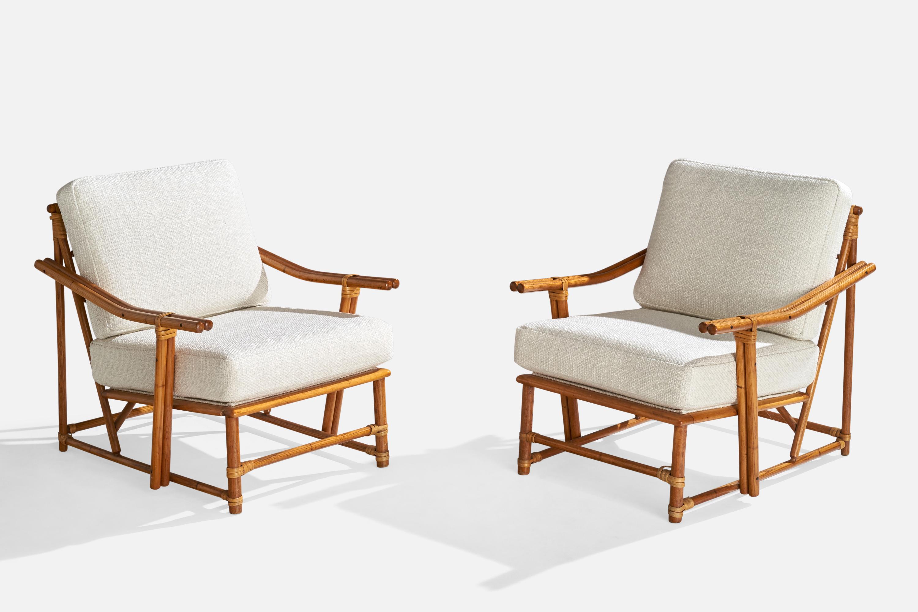 A pair of oak, rattan and white fabric lounge chairs designed and produced in the US, c. 1950s.

Seat height: 16.5