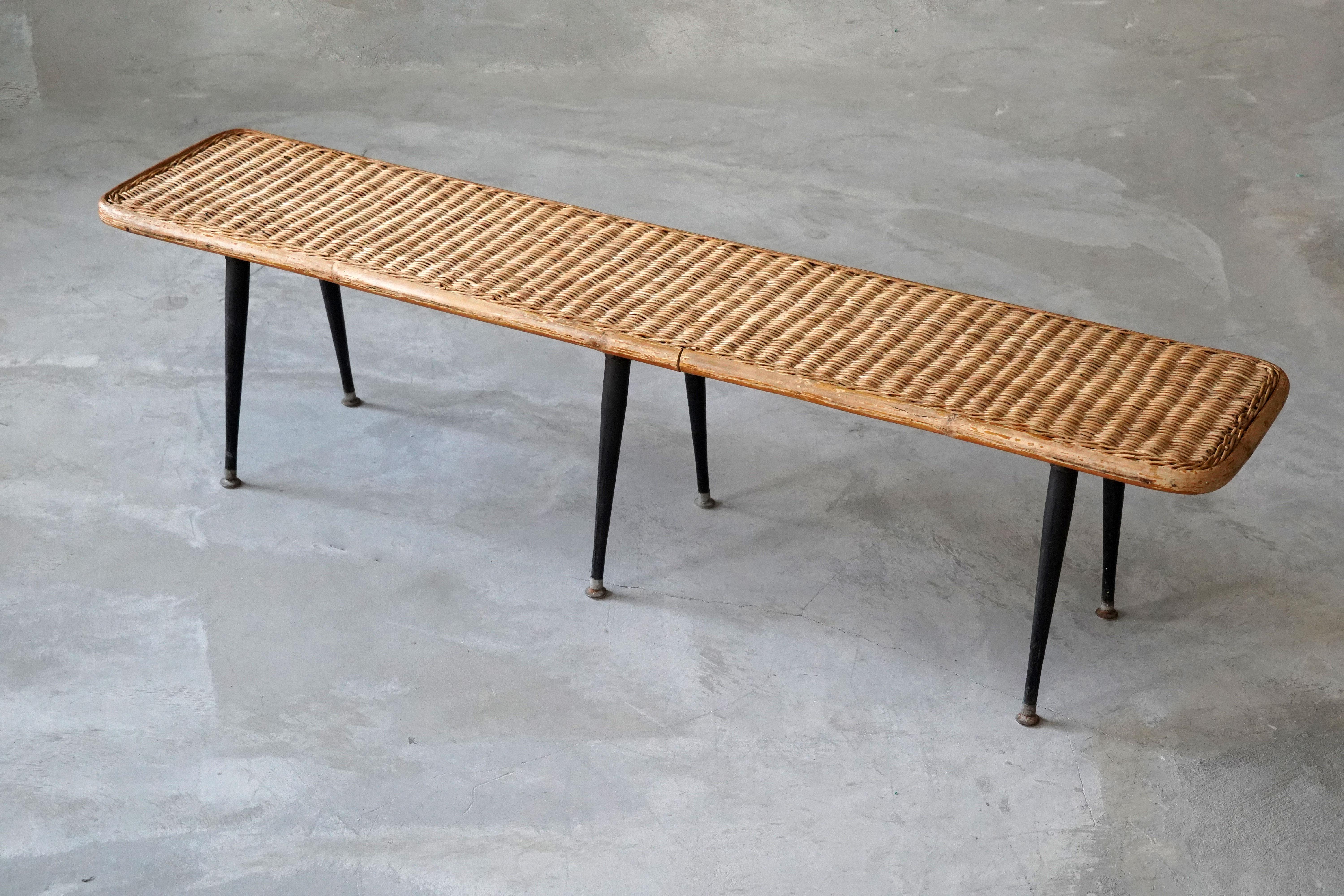 A bench. Designed and produced in America, 1950s. Woven rattan, bamboo, and lacquered steel.

Other designers of the period include Paul Frankl, Isamu Noguchi, George Nakashima, Edward Wormley, and Charles & Ray Eames.