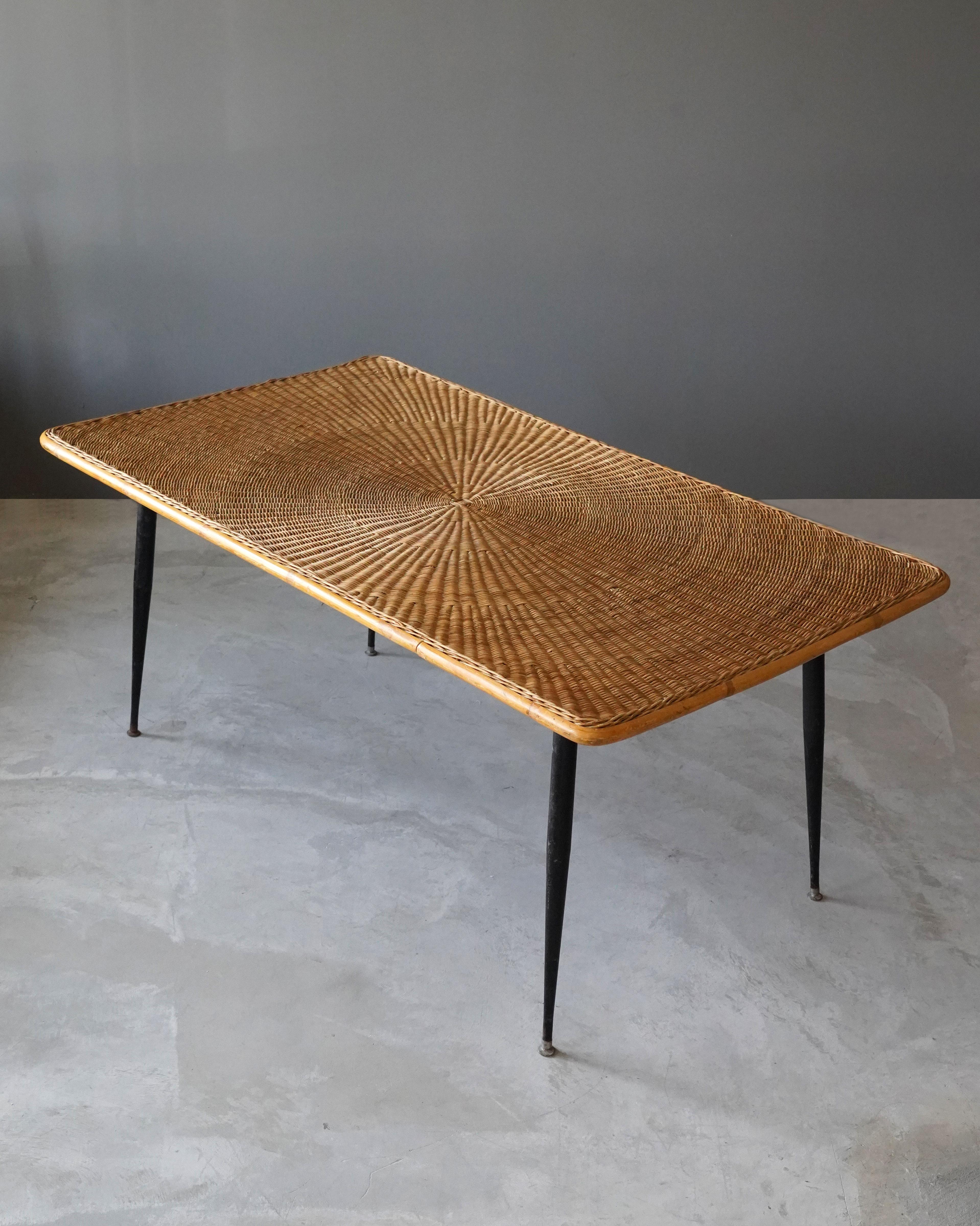 A dining table / dinette table / table. Designed and produced in America, 1950s. Woven rattan and lacquered steel.

Other designers of the period include Paul Frankl, Isamu Noguchi, George Nakashima, Edward Wormley, and Charles & Ray Eames.