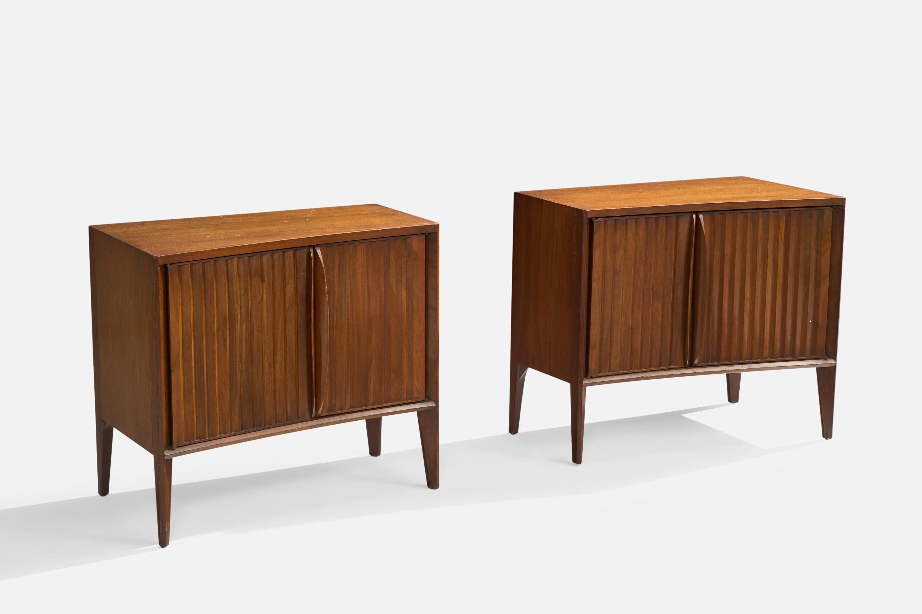 A pair of walnut nightstands designed and produced in the US, c. 1950s.

Very light scratching and a few small sports of discoloration on top surfaces, minor wear to edges of legs.

Dimensions: 24.75” H x 28.125” W x 16.75” D