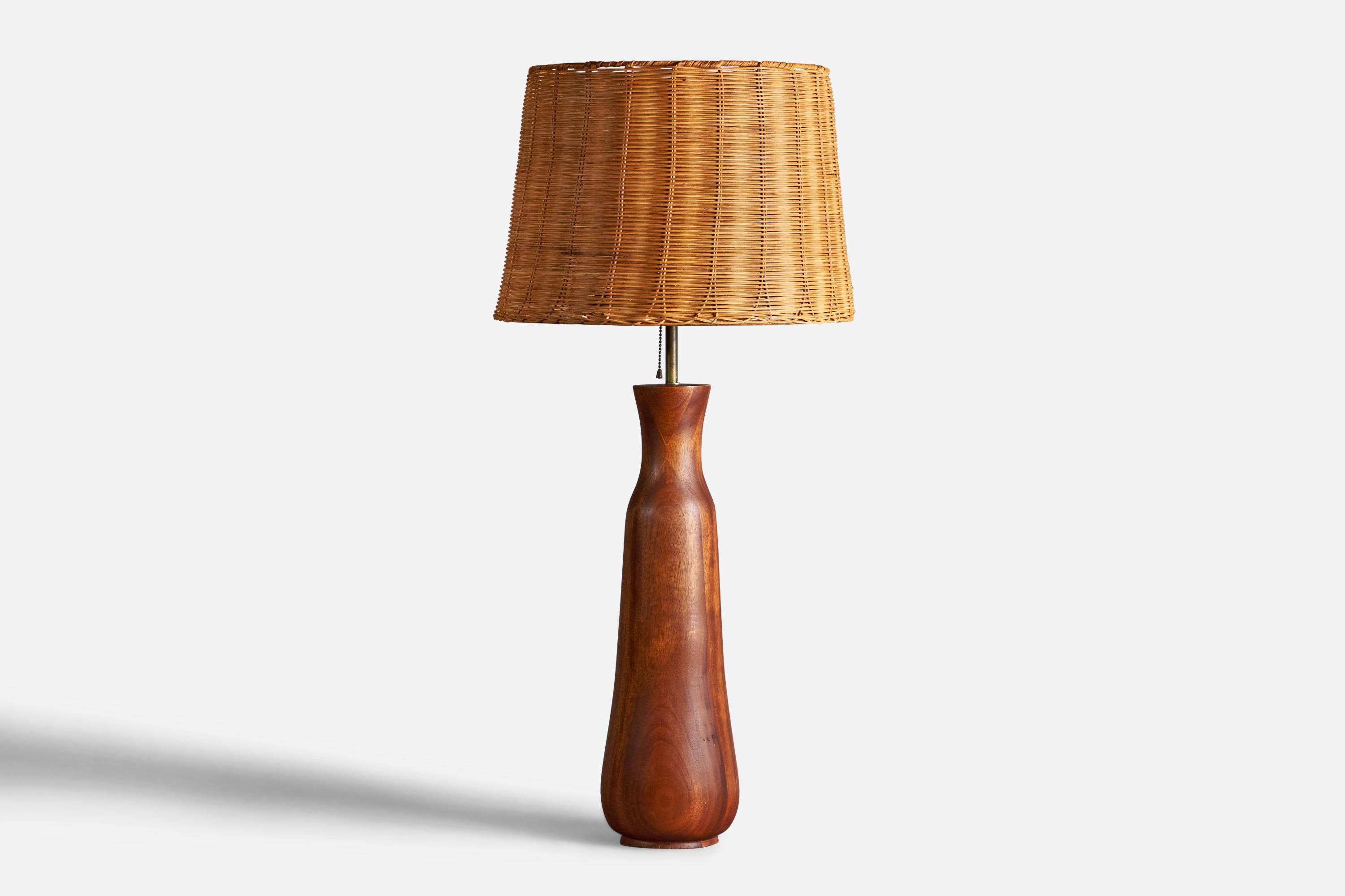 A sizeable teak, brass and rattan table lamp designed and produced in the US, c. 1950s.

Overall Dimensions (inches): 36” H x 16.5” Diameter
Bulb Specifications: E-26 Bulb
Number of Sockets: 1