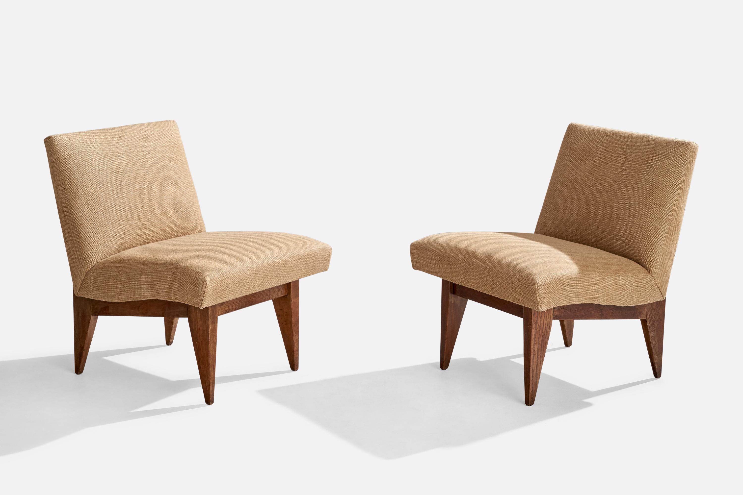 A pair of dark-stained oak and beige fabric lounge chairs designed and produced in the US, c. 1950s.

Seat height 17”
