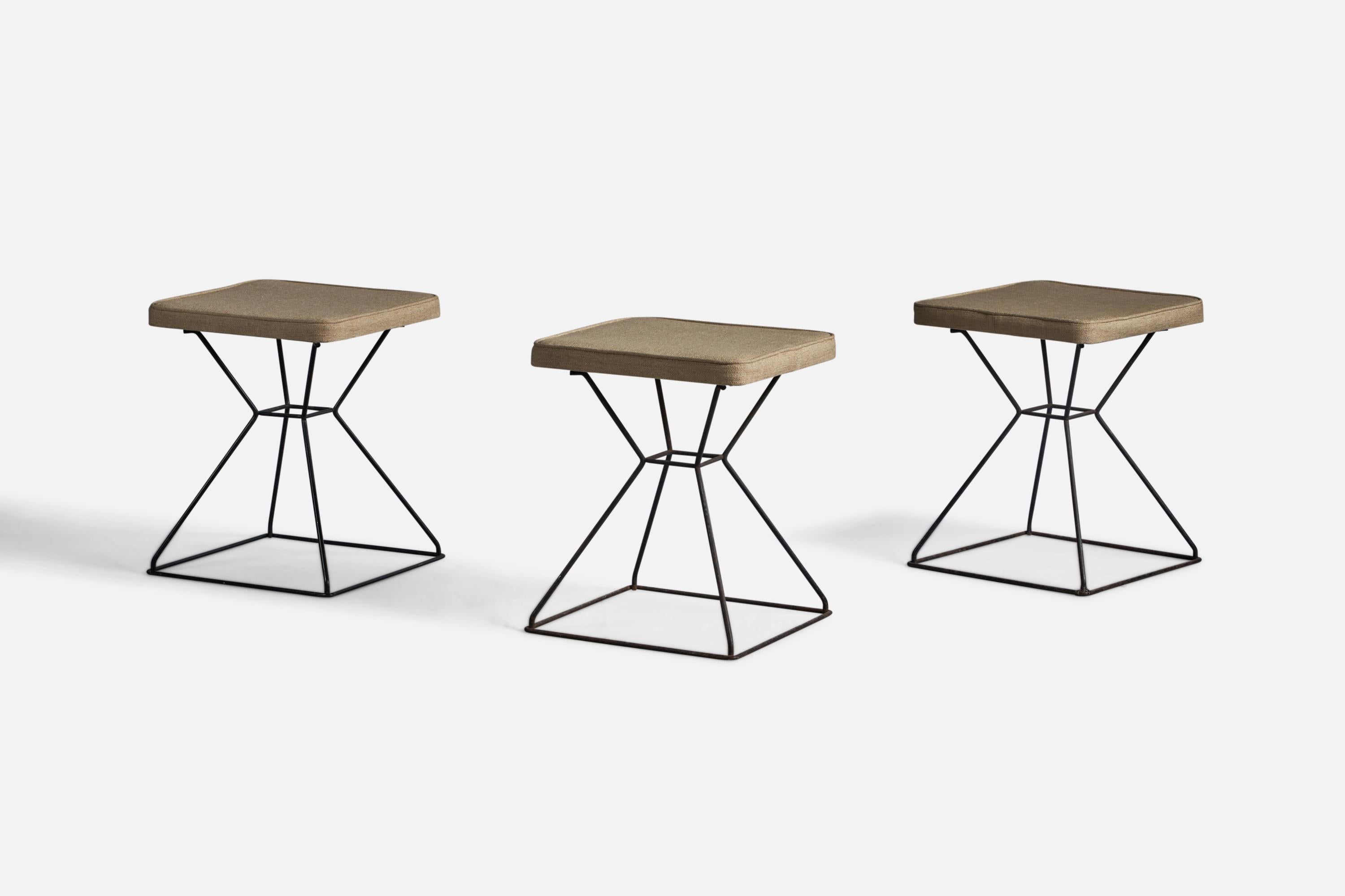 A set of three black-painted iron and beige fabric stools designed and produced in the US, 1950s.

