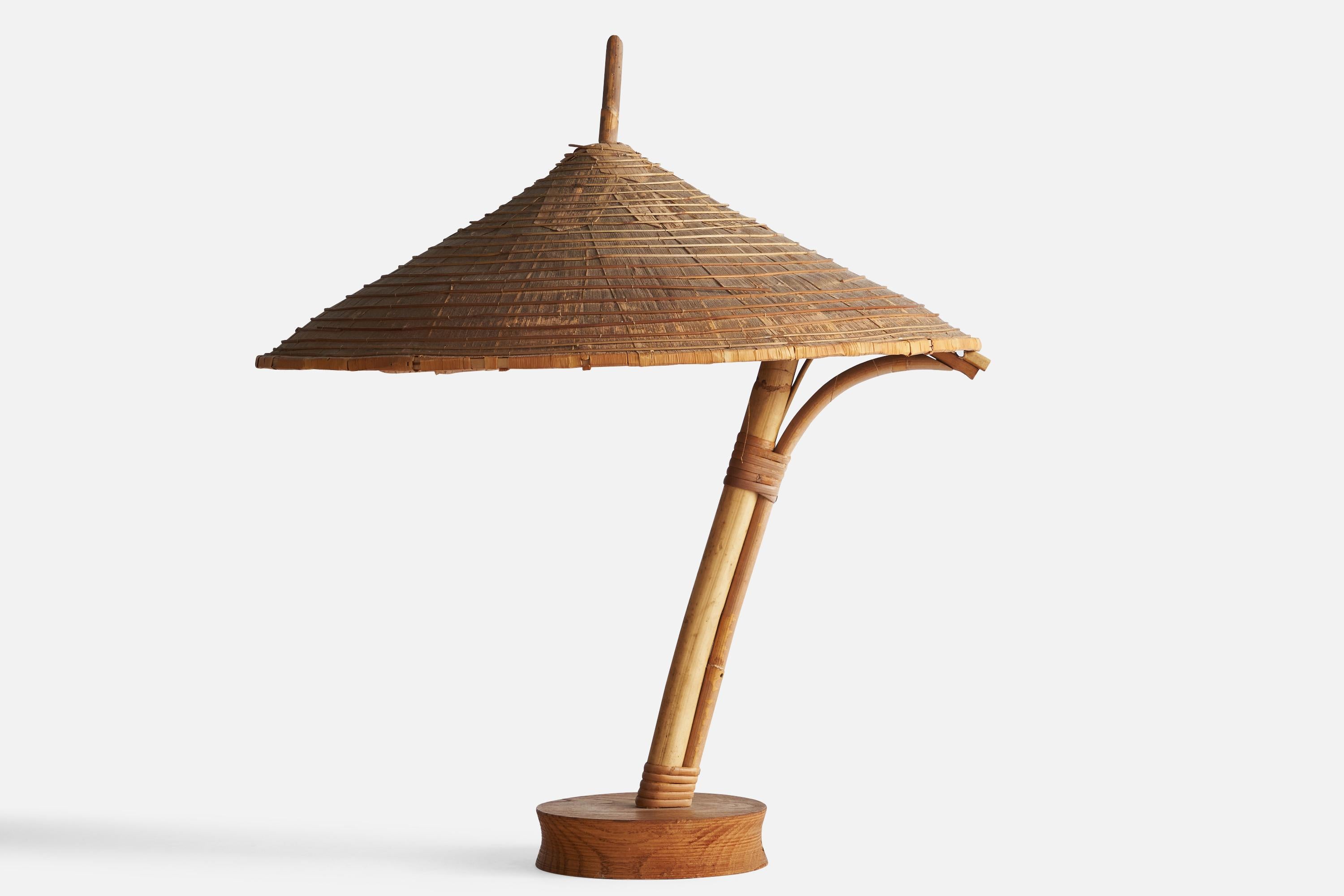 A bamboo, rattan and walnut table lamp designed and produced in the US, c. 1950s.

Overall Dimensions (inches): 20.8” H x 18” W x 18.5” D
Bulb Specifications: E-26 Bulb
Number of Sockets: 1
All lighting will be converted for US usage. We is unable