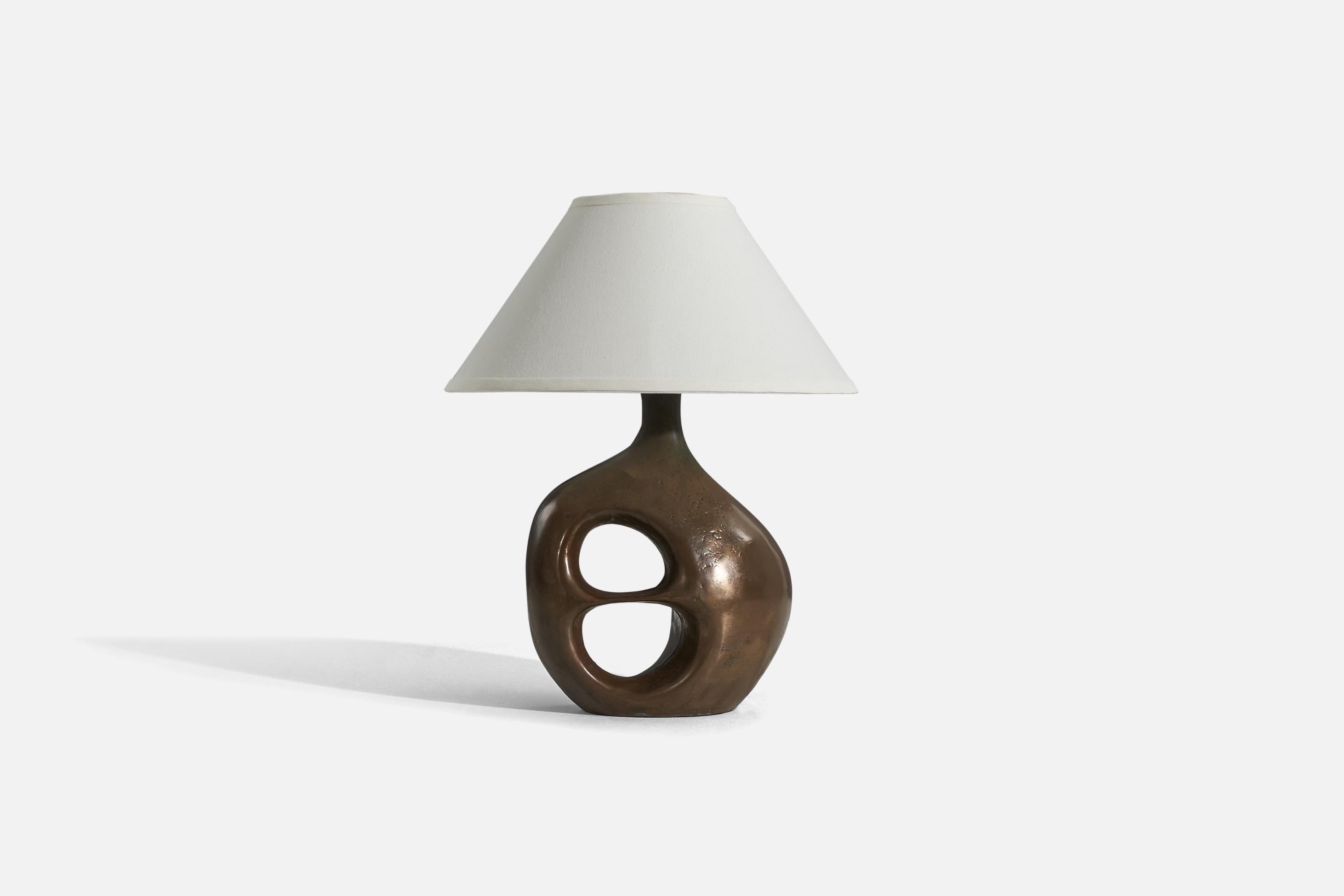 A bronze table lamp designed and produced in the United States, c. 1960s.

Sold without lampshade. 
Dimensions of Lamp (inches) : 17.5625 x 11.125 x 8 (H x W x D)
Dimensions of Shade (inches) : 6 x 16.25 x 9.25 (T x B x H)
Dimension of Lamp
