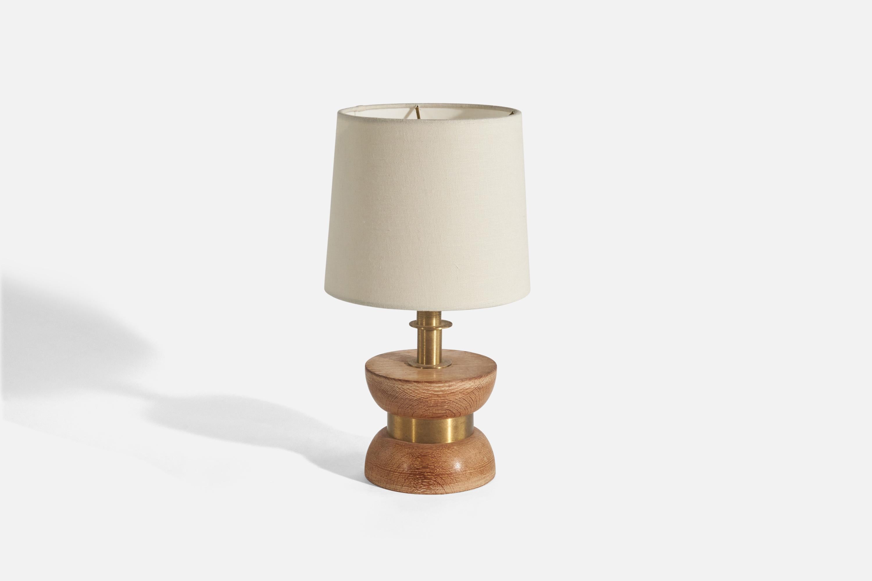 A brass and oak table lamp designed and produced in the United States, c. 1950s. 

Sold without Lampshade(s)
Dimensions of Lamp (inches) : 10.12 x 5.29 x 5.29 (Height x Width x Depth)
Dimensions of Shade (inches) : 7 x 8 x 7 (Top Diameter x Bottom