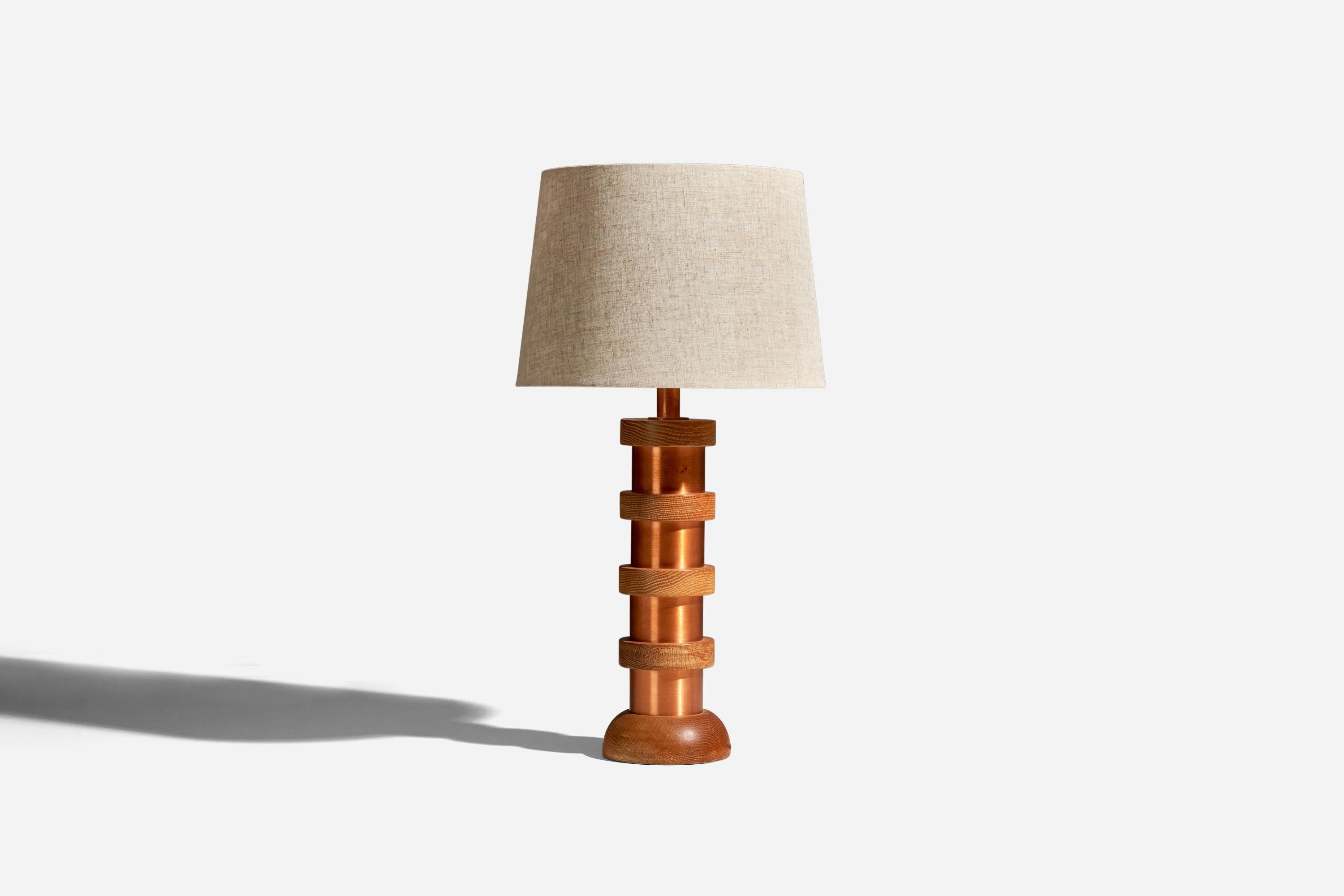 A copper and oak table lamp designed and produced by an American Designer, USA, 1950s.

Sold with Lampshade. Dimensions stated are of Table Lamp with Lampshade. 

Socket takes standard E-26 medium base bulb.

There is no maximum wattage stated