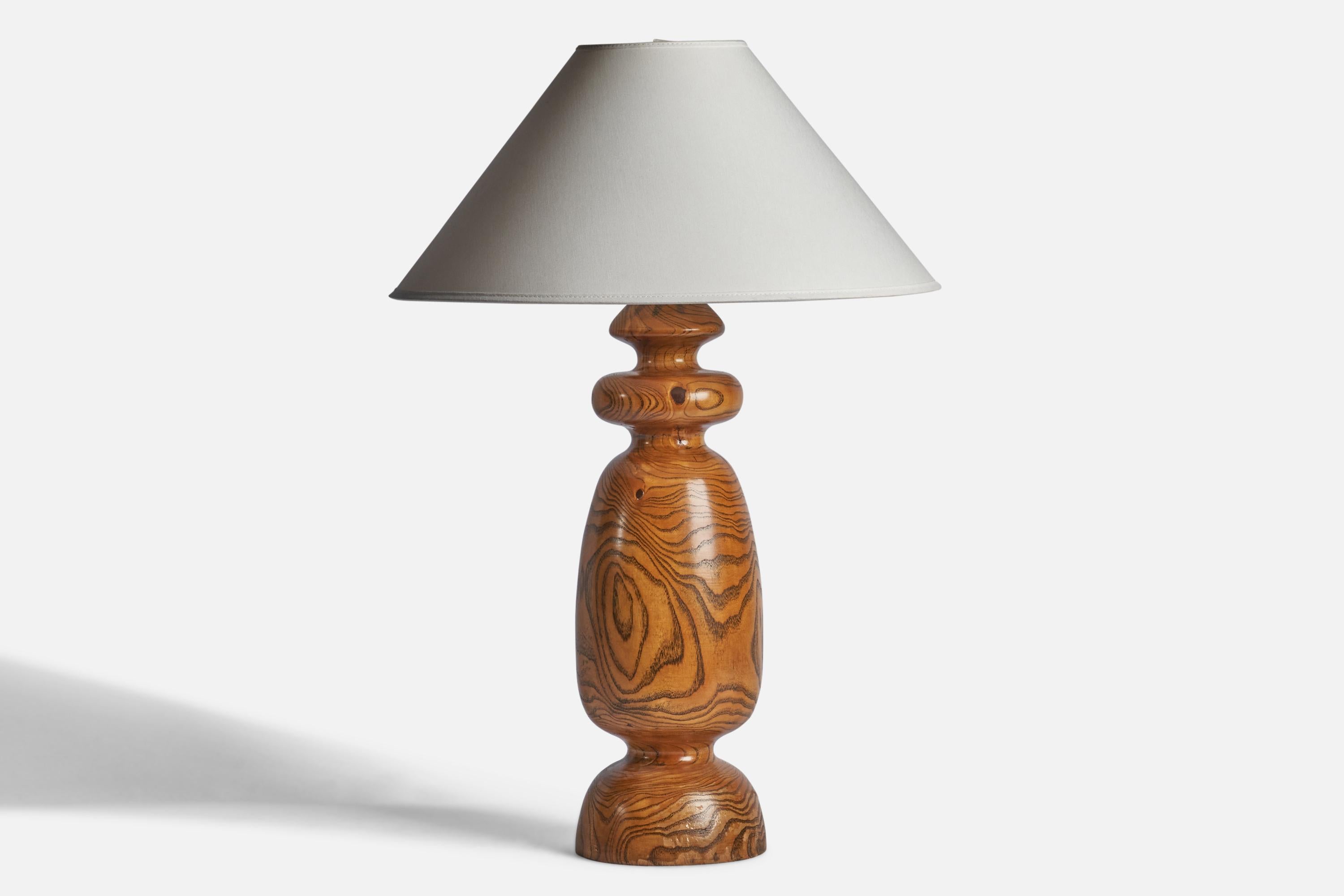 A turned pine table lamp designed and produced in the US, c. 1950s.

Dimensions of Lamp (inches): 19” H x 5.55” Diameter
Dimensions of Shade (inches): 4.5” Top Diameter x 16” Bottom Diameter x 7.15” H 
Dimensions of Lamp with Shade (inches): 23.95”